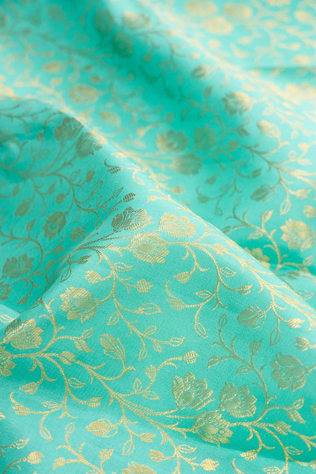 Close up of Turquoise Kanjivaram Silk Saree with Zari Brocade on the body and Zari Border.  displaying folds