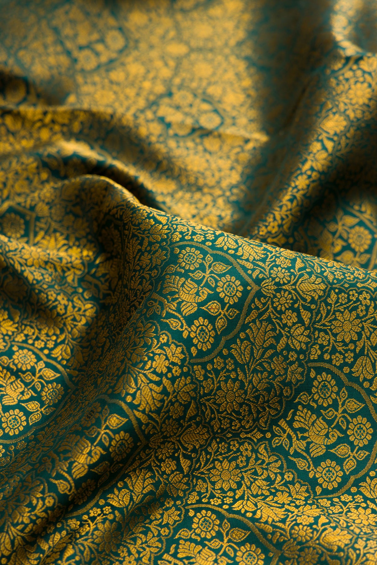 Close up of Pure Silk Bottle Green Kanjivaram Saree with Zari Brocade on the body and Zari Border.  displaying folds