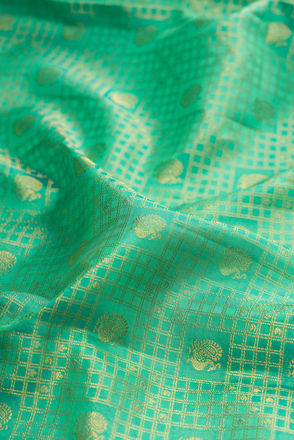 Close up of Green Kanjivaram Silk Saree with Zari Brocade on the body and Zari Border.  displaying folds