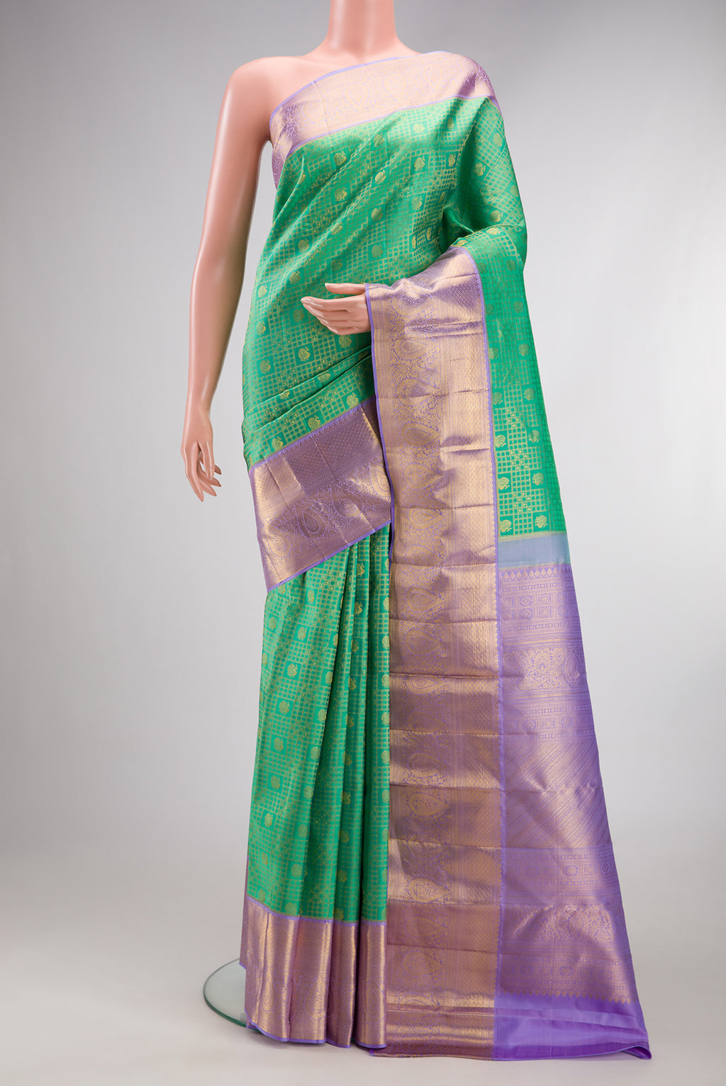 Green Kanjivaram Silk Saree with Zari Brocade on the body and Zari Border.  displayed on a mannequin