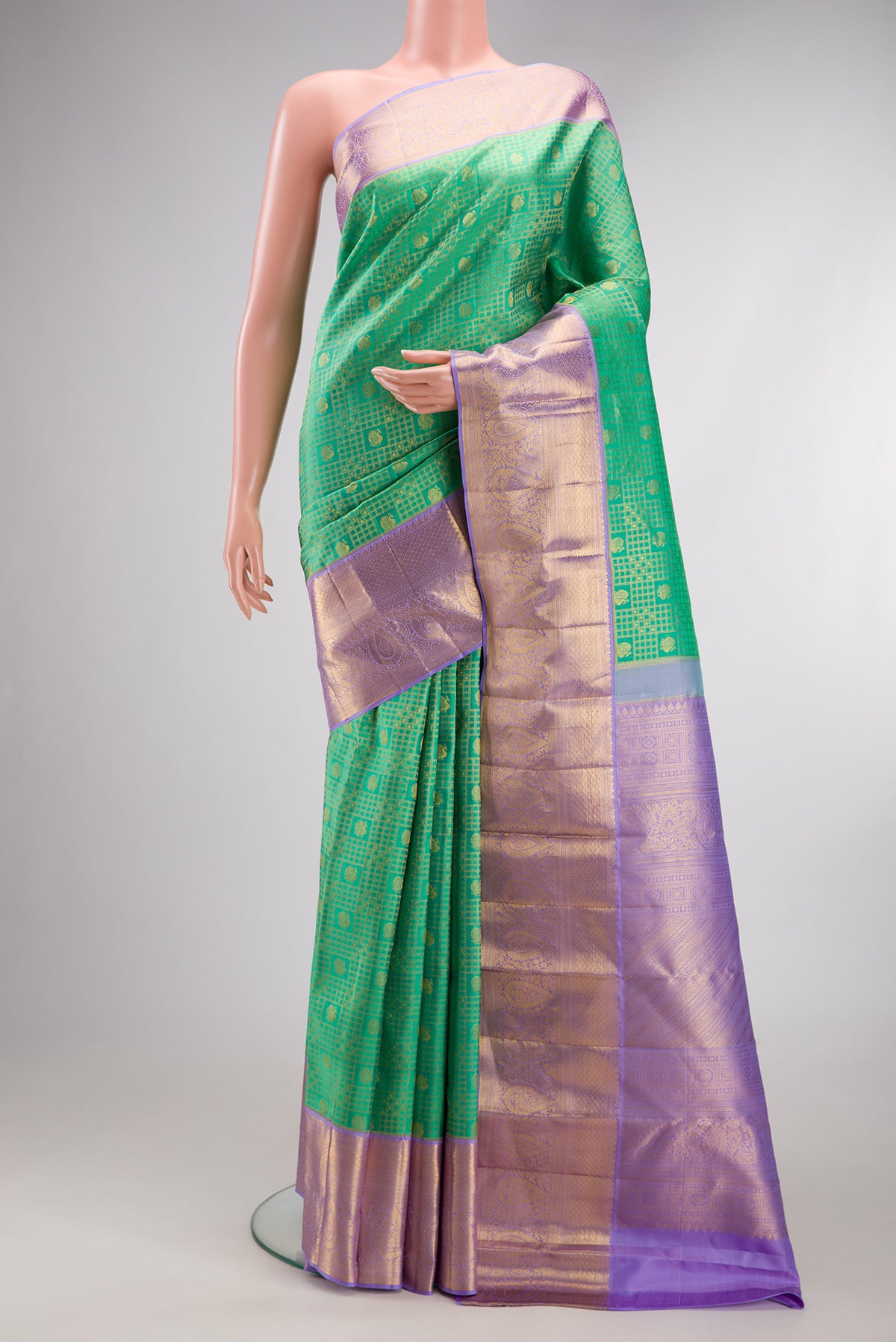 Green Kanjivaram Silk Saree with Zari Brocade on the body and Zari Border.  displayed on a mannequin