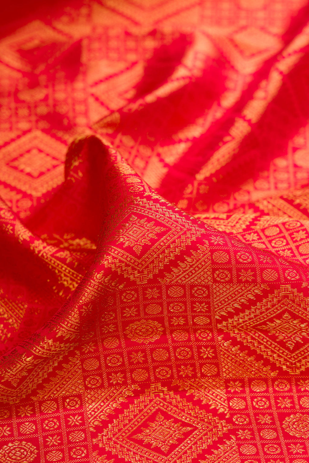 Close up of Pure Silk Red Kanchipuram Saree with Zari Brocade on the body and Zari Border.  displaying folds