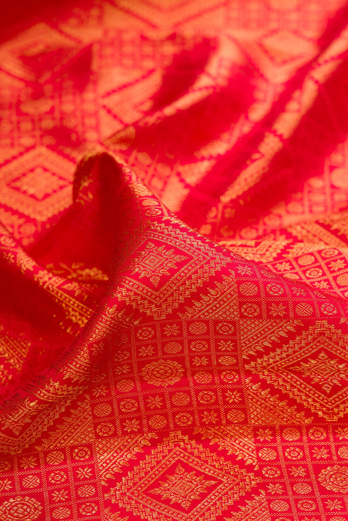Close up of Pure Silk Red Kanchipuram Saree with Zari Brocade on the body and Zari Border.  displaying folds