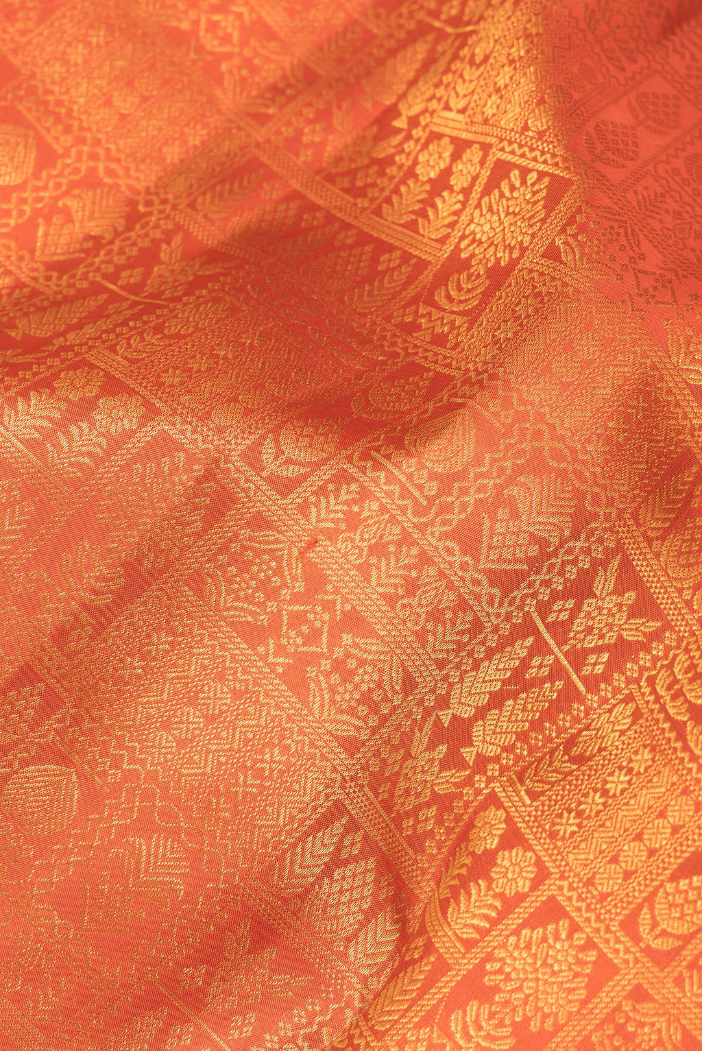 Close up of Pure Silk Orange Kanchipuram Saree with Zari Brocade on the body and Fancy Border.  displaying folds
