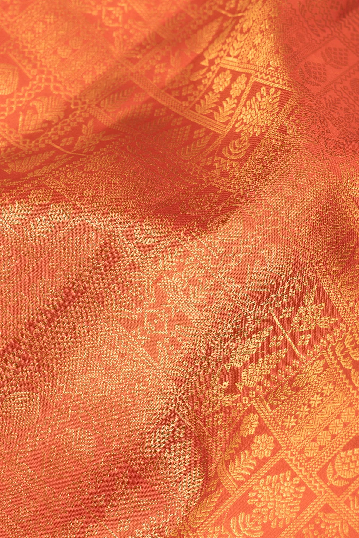 Close up of Pure Silk Orange Kanchipuram Saree with Zari Brocade on the body and Fancy Border.  displaying folds