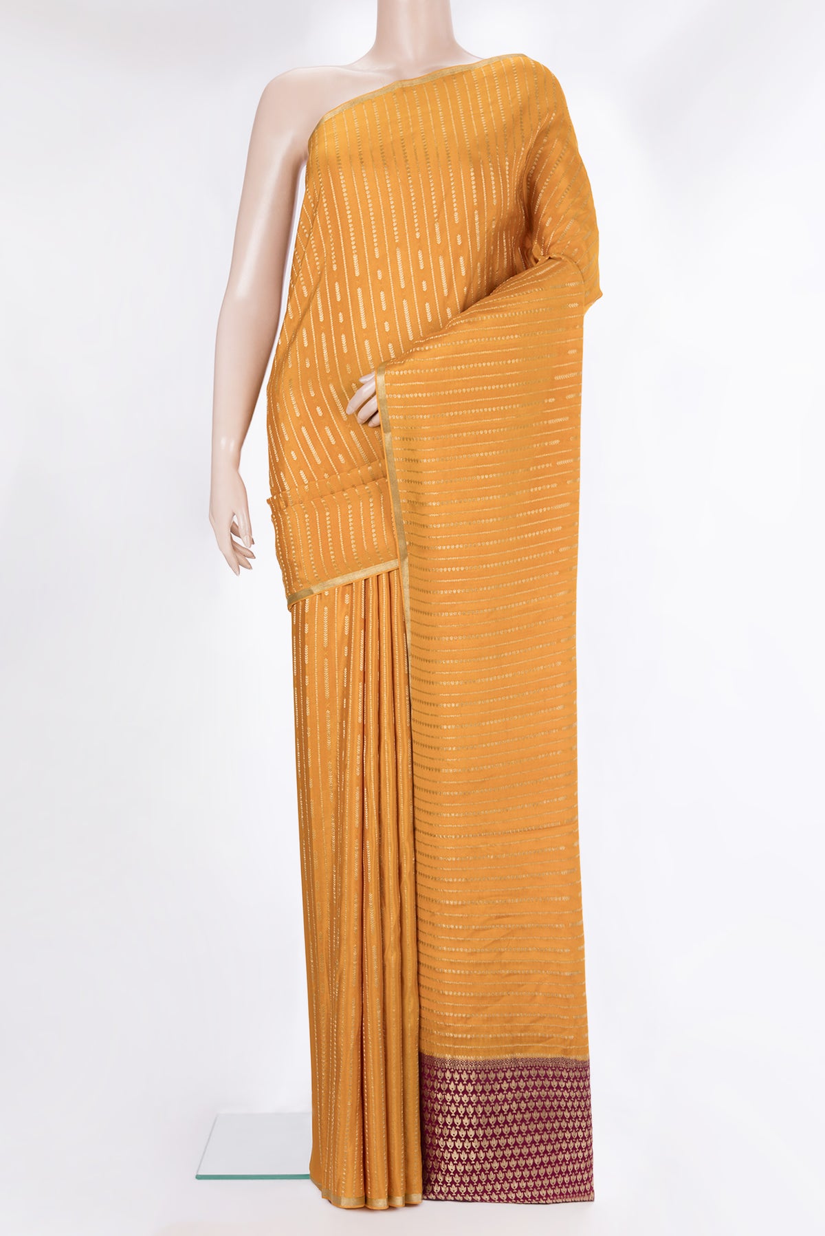 Mustard Mysore Crepe Saree with Stripes on the body and Zari Border.  displayed on a mannequin