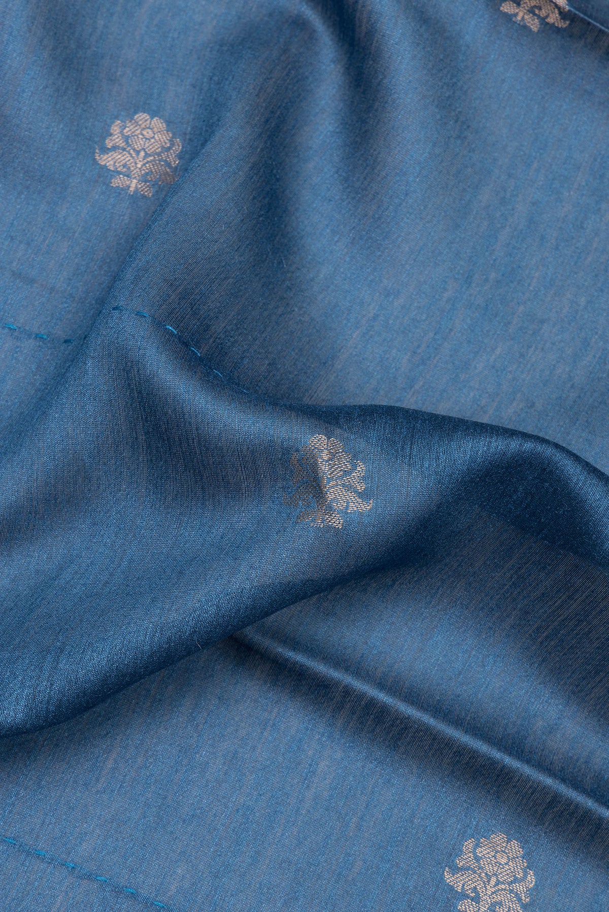 Close up of Blue Tussar Saree with Zari Butta on the body and Embroidered Border.  displaying folds