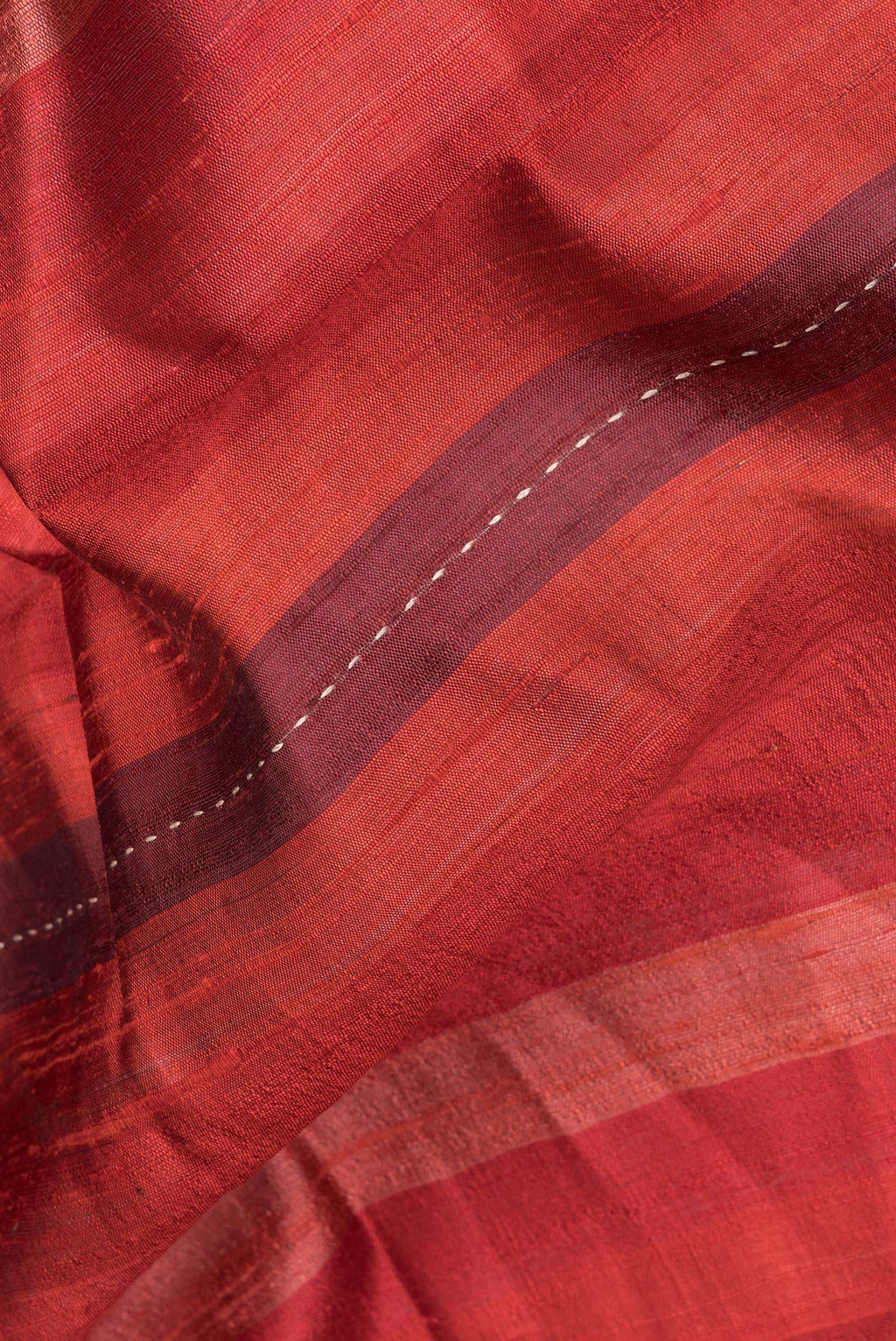 Close up of Pure Silk Maroon Dual Tone Tussar Saree with Stripes on the body and Embroidery Border.  displaying folds