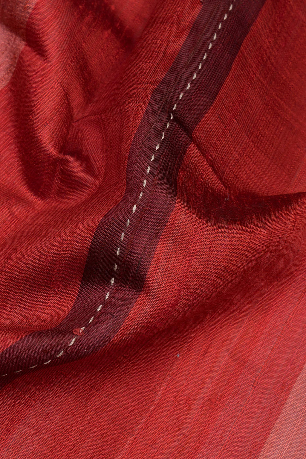 Close up of Pure Silk Maroon Dual Tone Tussar Saree with Stripes on the body and Embroidery Border.  displaying folds