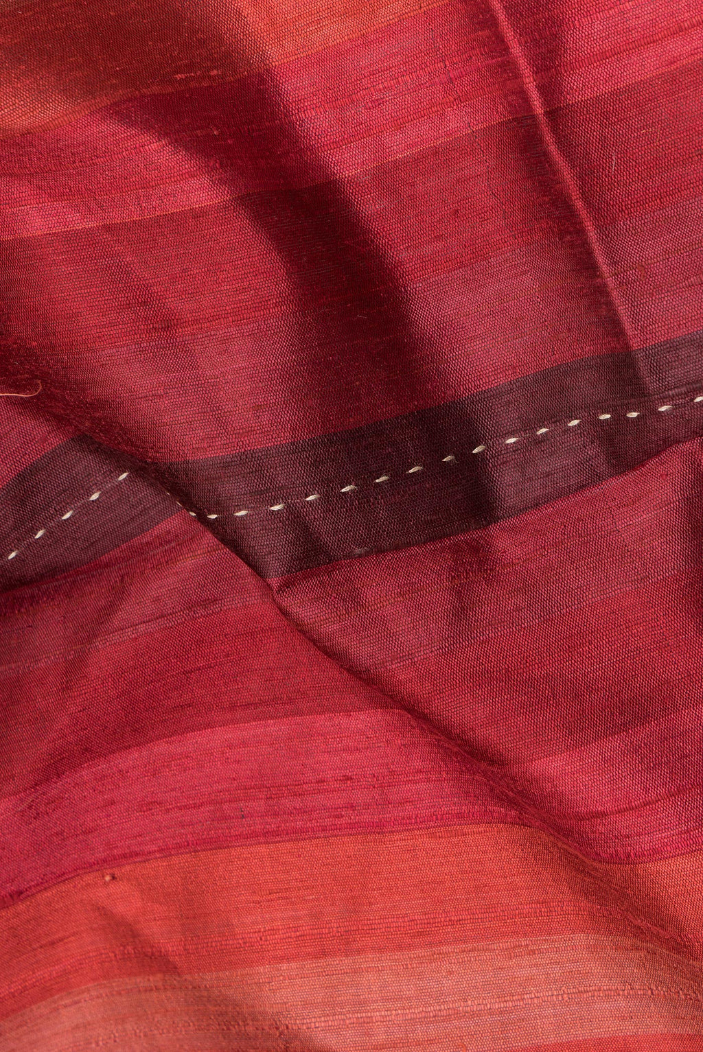 Close up of Pure Silk Maroon Dual Tone Tussar Saree with Stripes on the body and Embroidery Border.  displaying folds