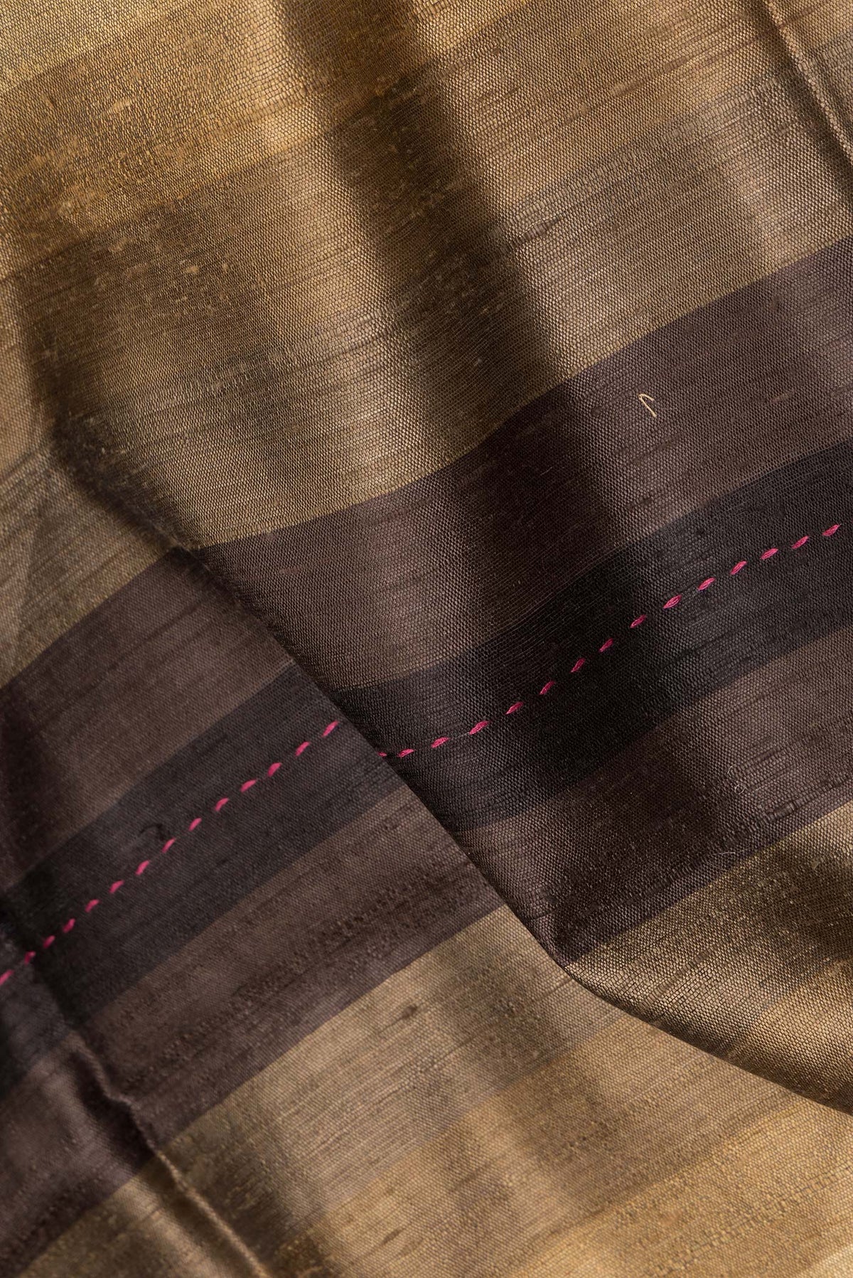 Close up of Pure Silk Brown Dual Tone Tussar Saree with Stripes on the body and Embroidery Border.  displaying folds