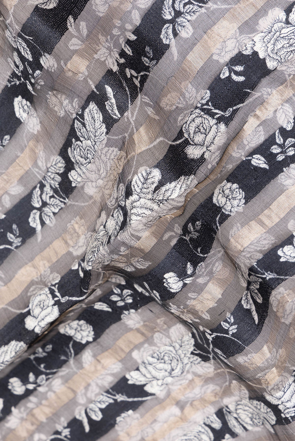 Close up of Pure Silk Navy Blue Dual Tone Tussar Saree with Printed design on the body and Fancy Border.  displaying folds
