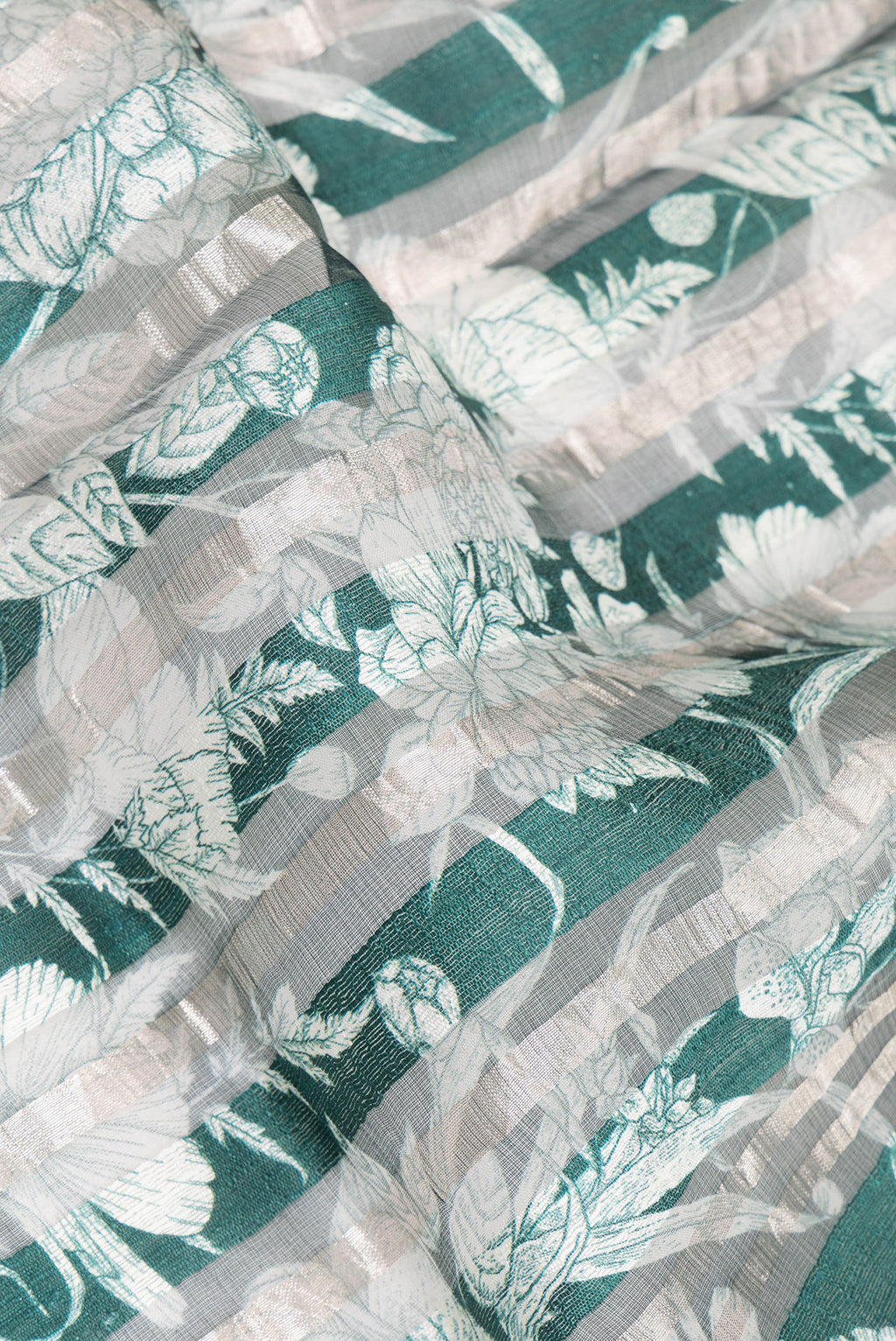 Close up of Pure Silk Green Dual Tone Tussar Saree with Printed design on the body and Fancy Border.  displaying folds
