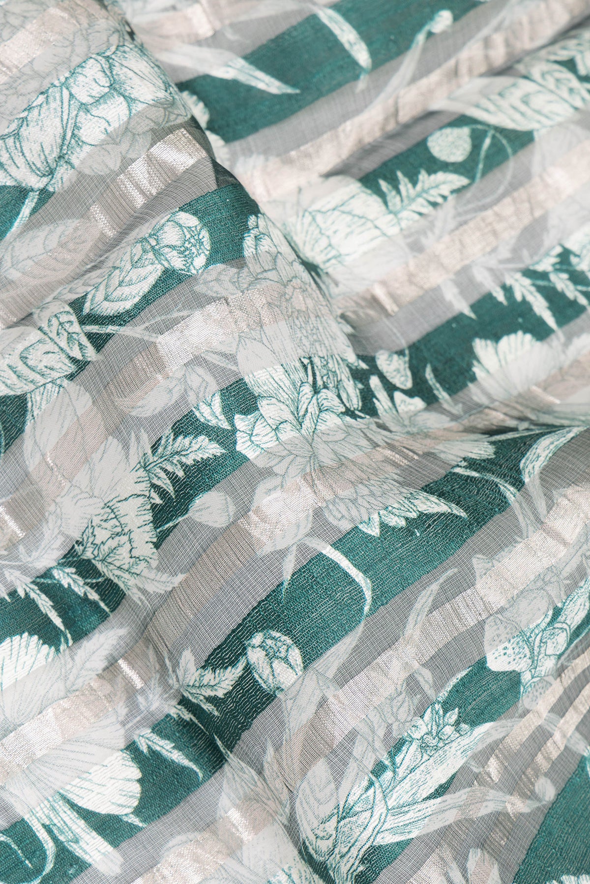 Close up of Pure Silk Green Dual Tone Tussar Saree with Printed design on the body and Fancy Border.  displaying folds