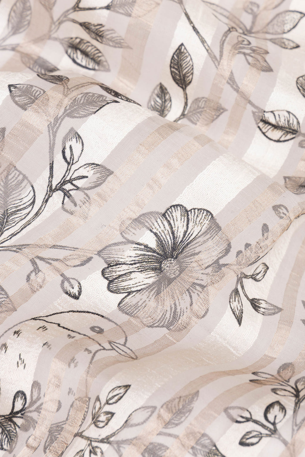 Close up of Pure Silk Off White Dual Tone Tussar Saree with Printed design on the body and Fancy Border.  displaying folds