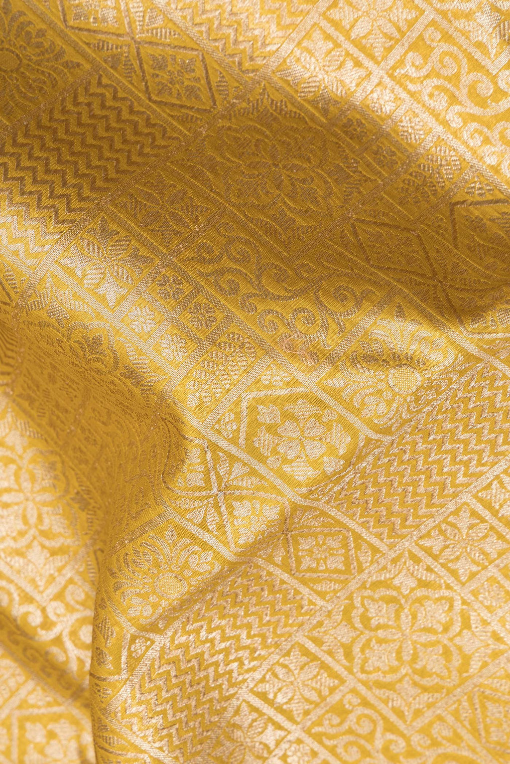 Close up of Pure Silk Mustard Dual Tone Chanderi Saree with Zari Brocade on the body and Zari Border.  displaying folds