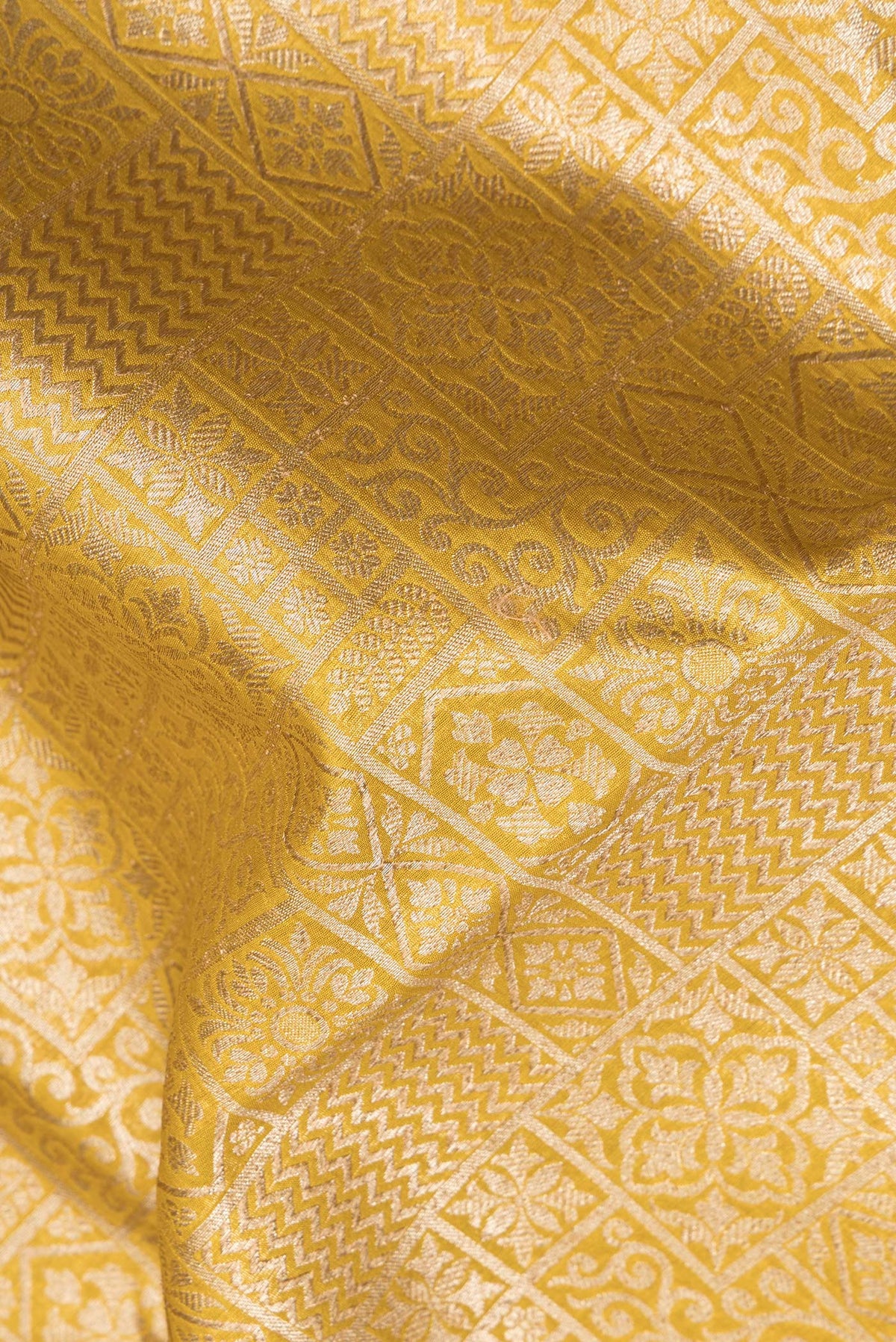 Close up of Pure Silk Mustard Dual Tone Chanderi Saree with Zari Brocade on the body and Zari Border.  displaying folds
