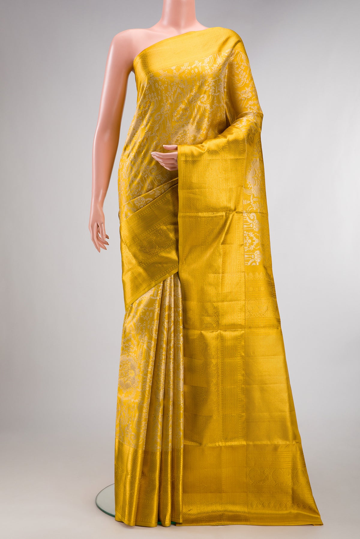 Yellow Dual Tone Kanjivaram Tissue Saree with Zari Brocade on the body and Zari Border.  displayed on a mannequin