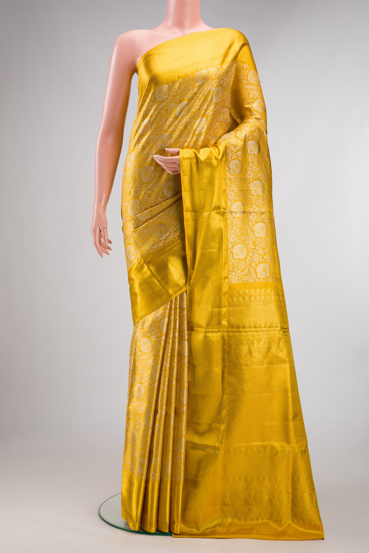 Yellow Kanjivaram Tissue Saree with Zari Brocade on the body and Zari Border.  displayed on a mannequin