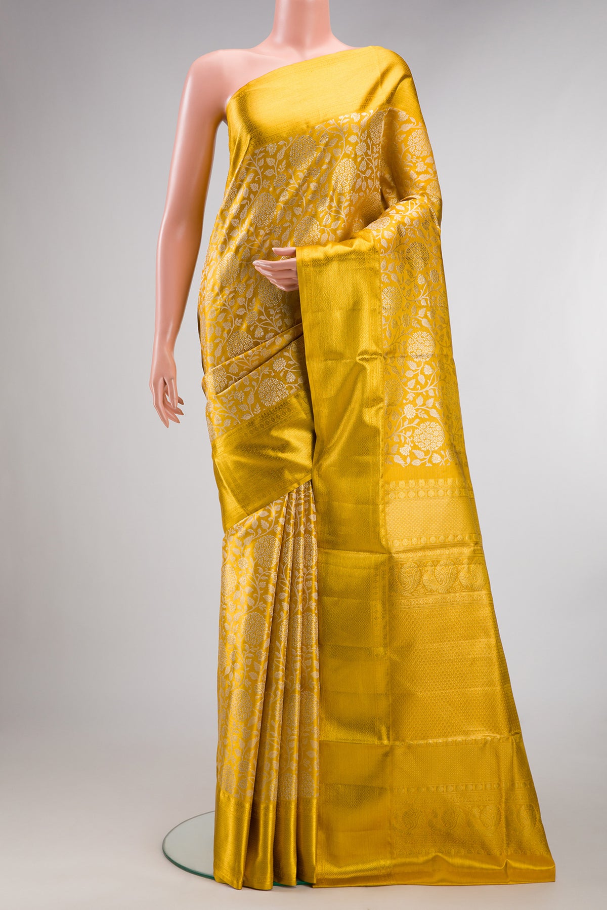 Yellow Dual Tone Kanjivaram Tissue Saree with Zari Brocade on the body and Zari Border.  displayed on a mannequin