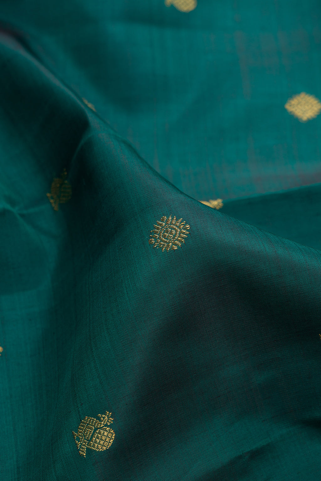 Close up of Pure Silk Pure Zari Green Kanjivaram Saree with Zari Butta on the body and Zari Border.  displaying folds