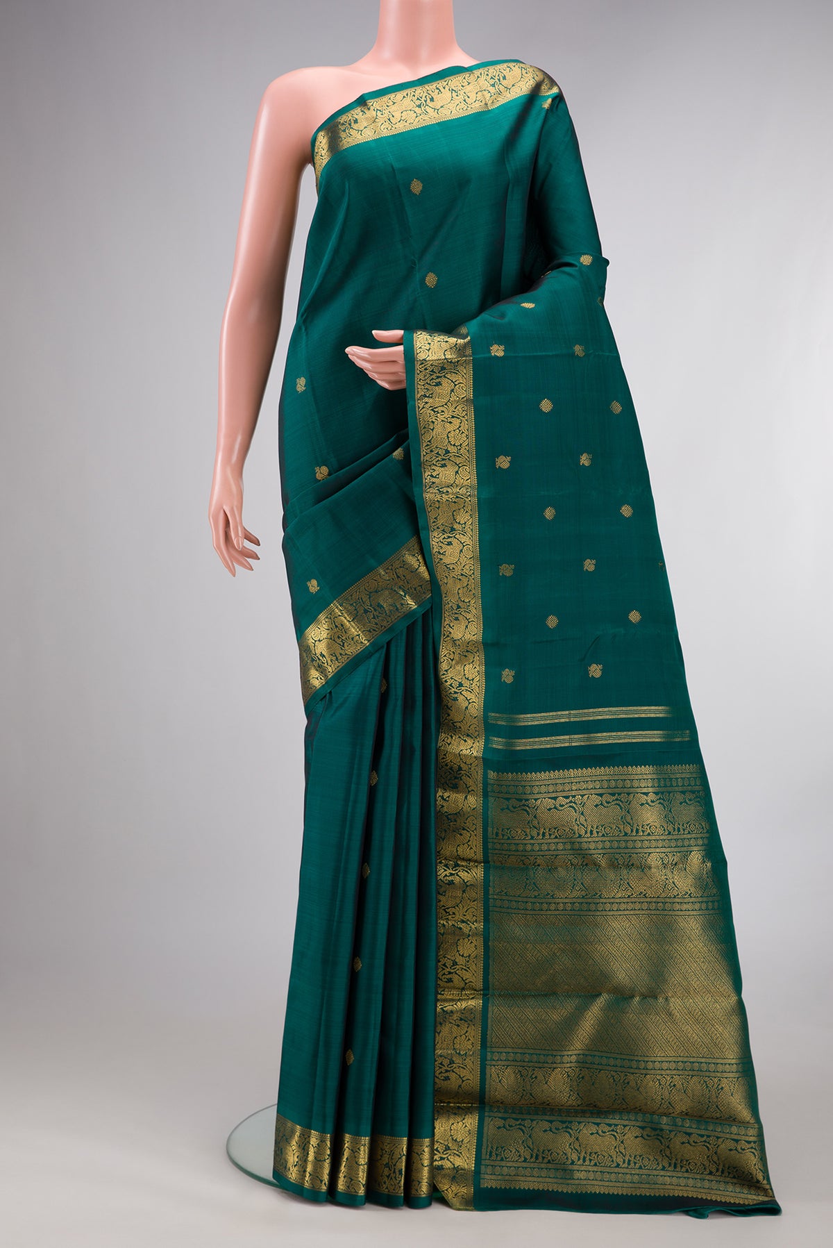 Pure Silk Pure Zari Green Kanjivaram Saree with Zari Butta on the body and Zari Border.  displayed on a mannequin