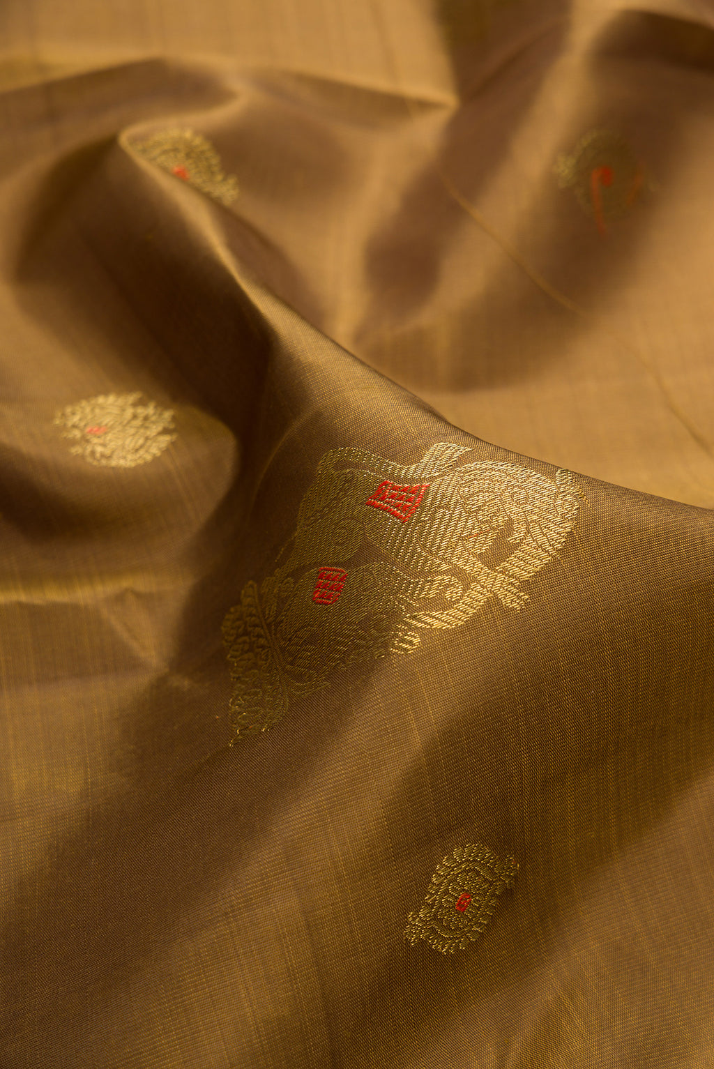 Close up of Pure Silk Pure Zari Mehandi Green Kanjivaram Saree with Zari Butta on the body and Zari Border.  displaying folds