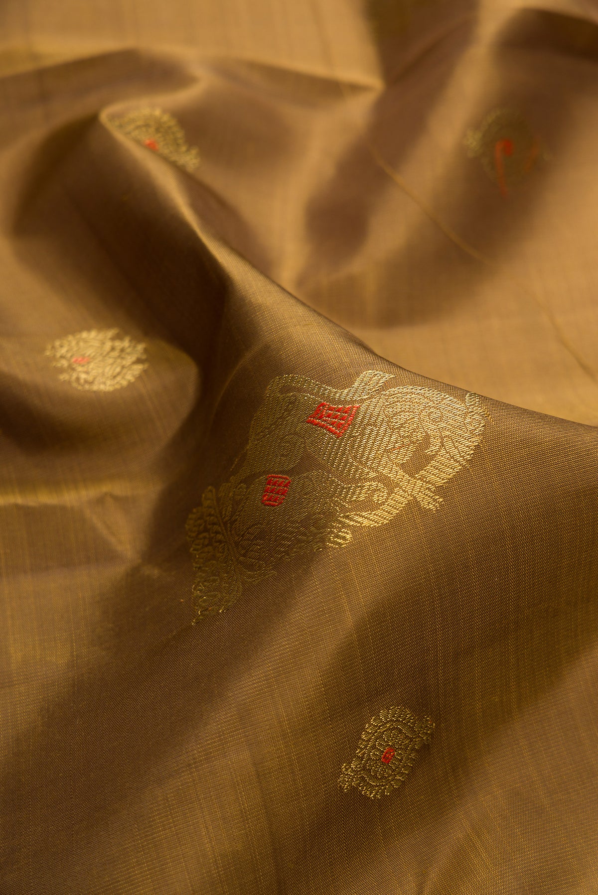 Close up of Pure Silk Pure Zari Mehandi Green Kanjivaram Saree with Zari Butta on the body and Zari Border.  displaying folds