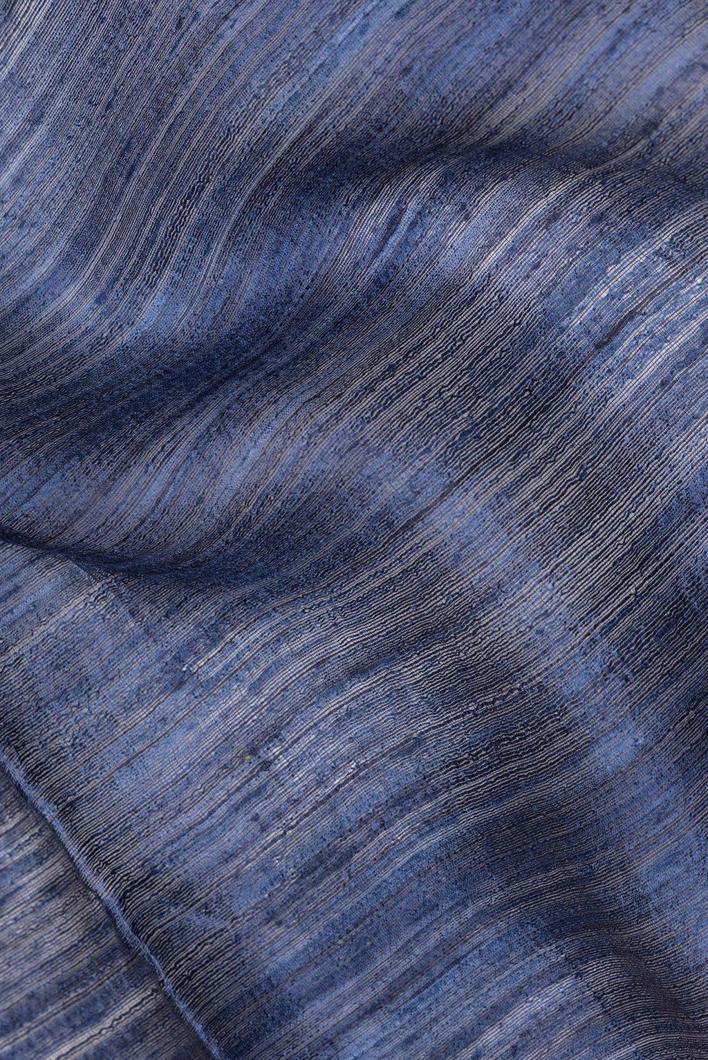Close up of Navy Blue Tussar Saree with Plain Body and Zari Border.  displaying folds