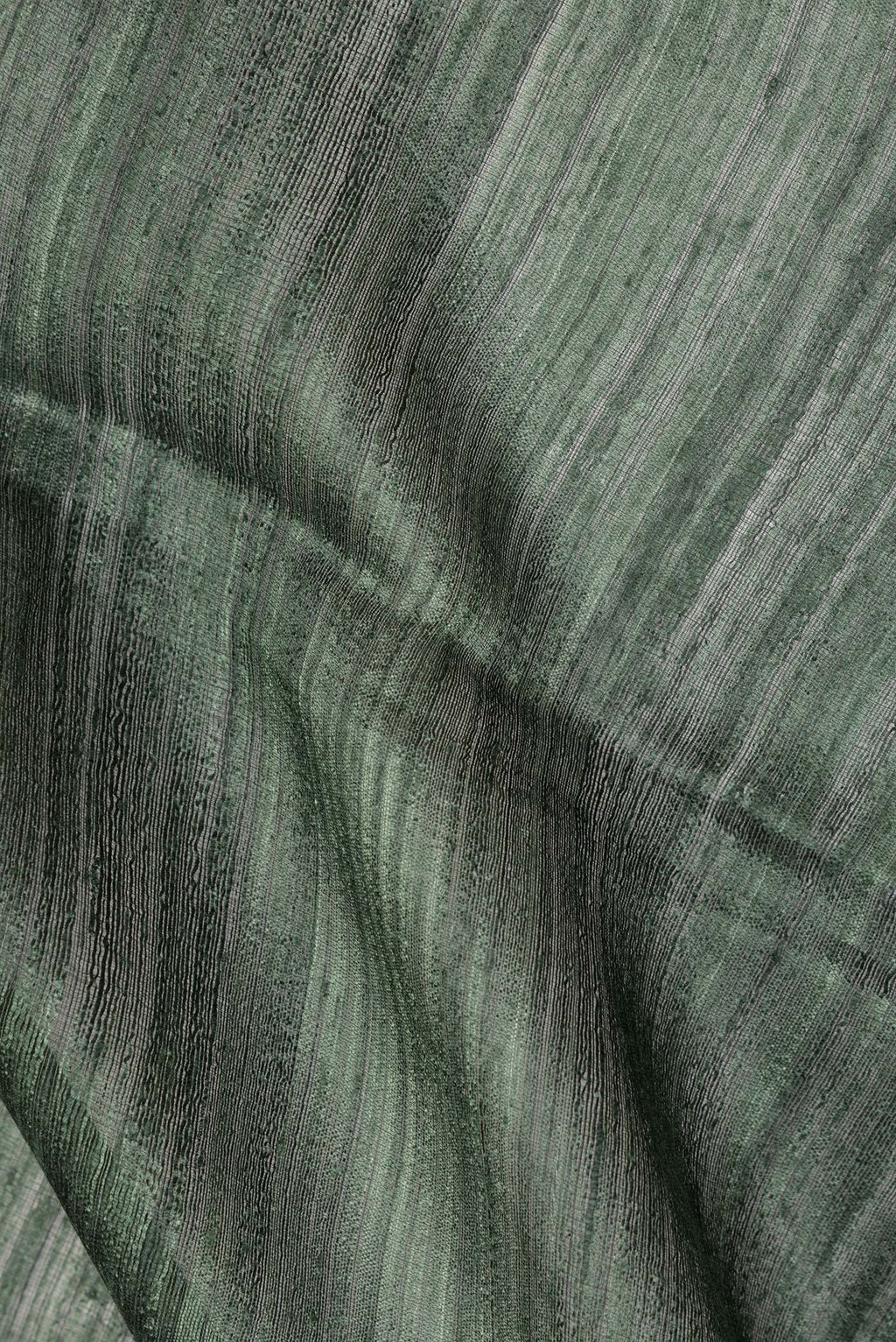 Close up of Bottle Green Tussar Saree with Zari Butta on the body and Fancy Border.  displaying folds