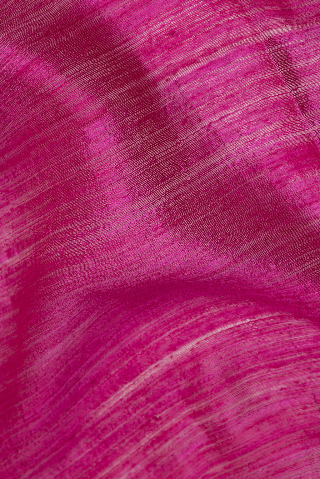 Close up of Magenta Tussar Saree with Zari Butta on the body and Fancy Border.  displaying folds