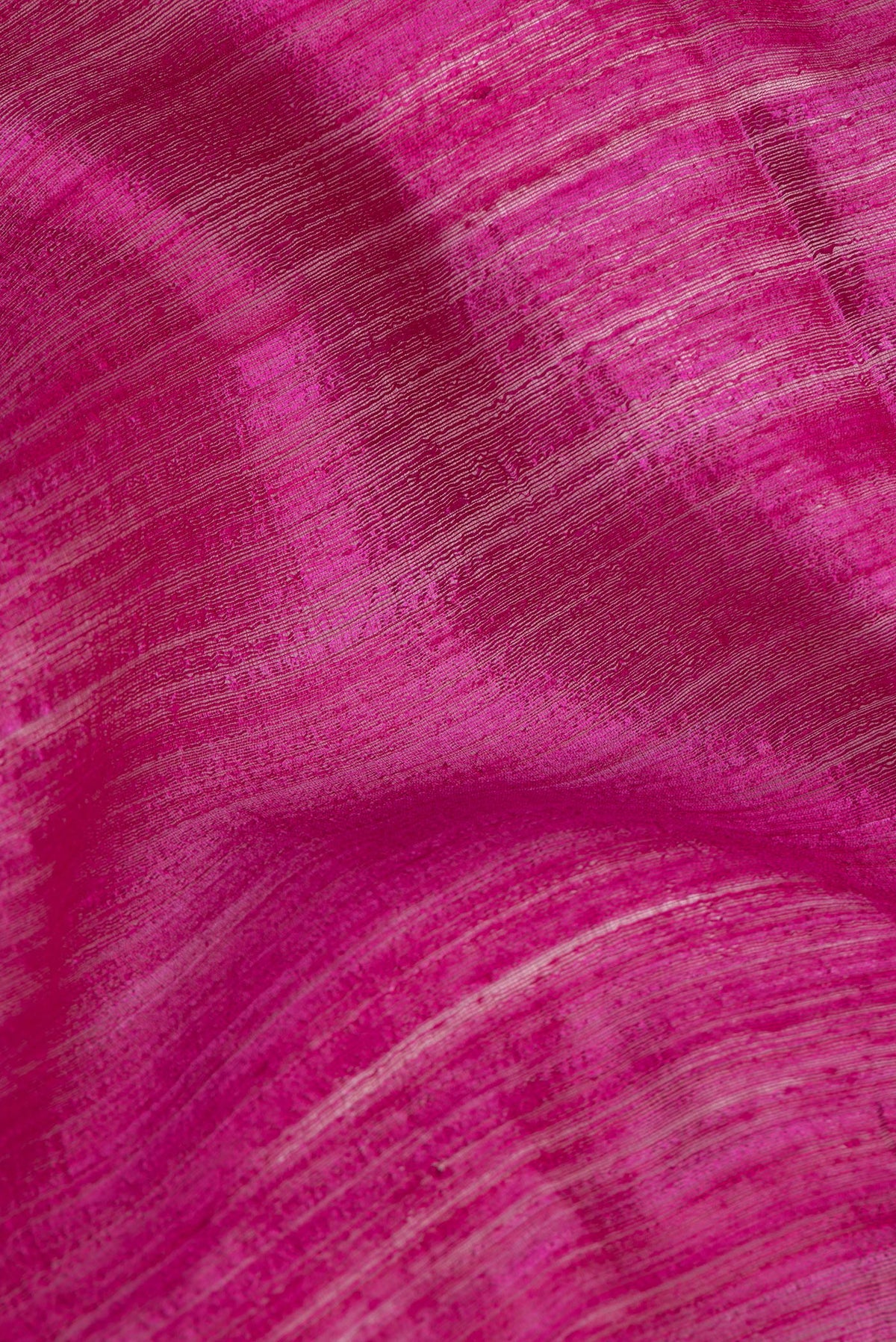 Close up of Magenta Tussar Saree with Zari Butta on the body and Fancy Border.  displaying folds