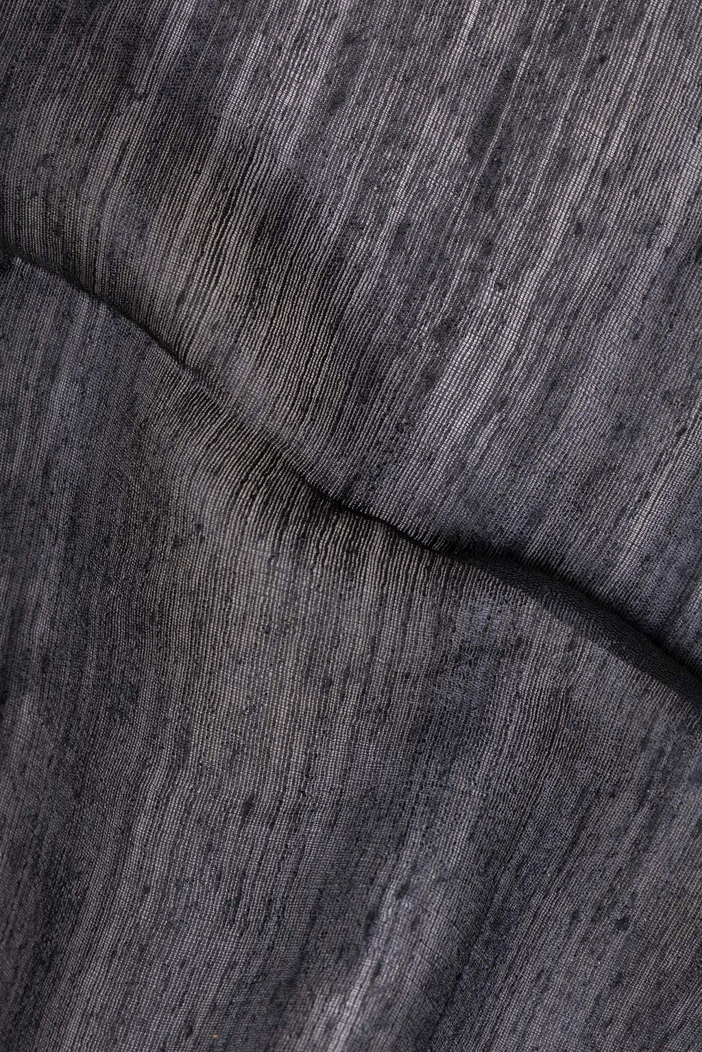 Close up of Pure Silk Black Tussar Saree with Plain Body and Zari Border.  displaying folds
