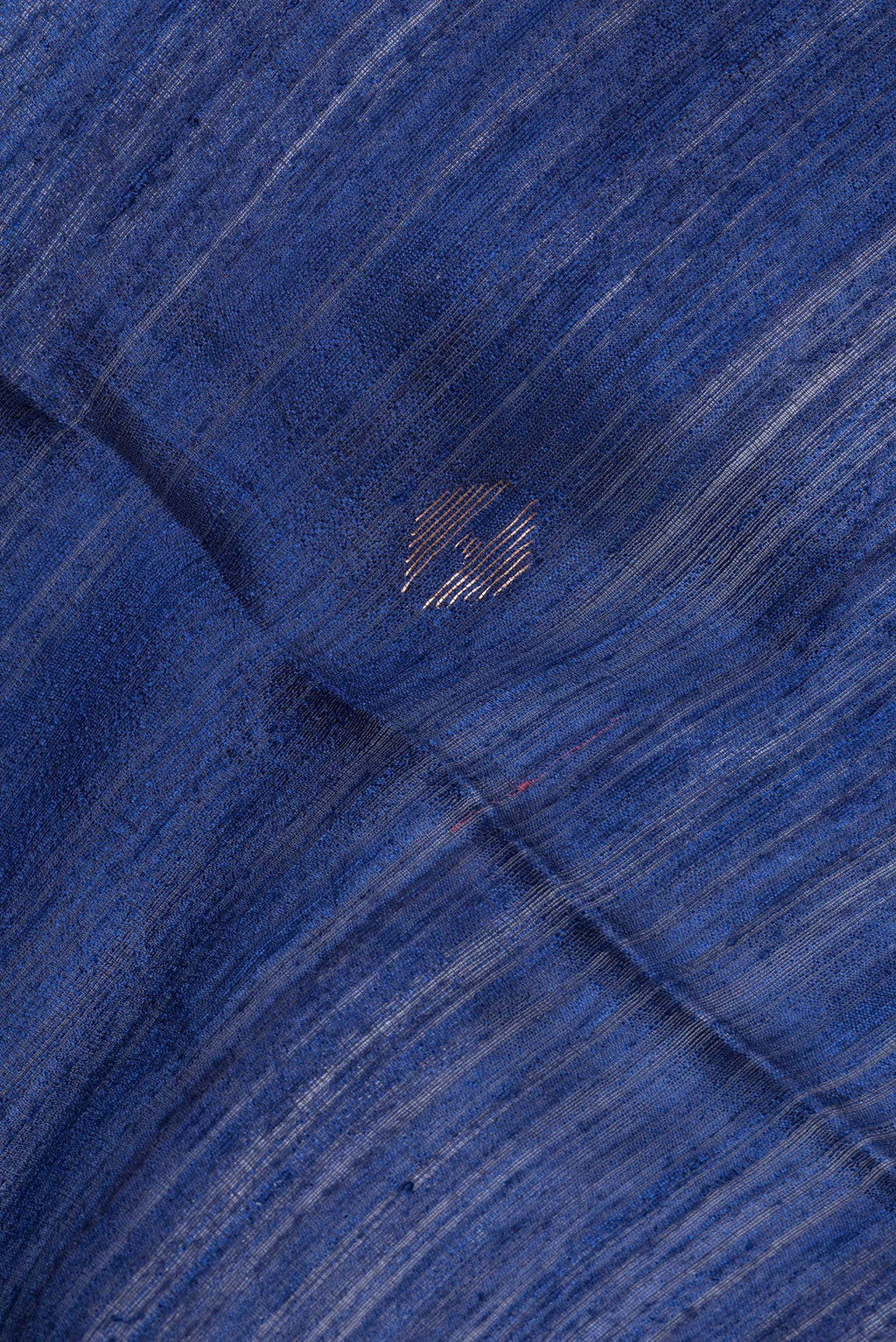 Close up of Pure Silk Navy Blue Dual Tone Jute Saree with Zari Butta on the body and Zari Border.  displaying folds