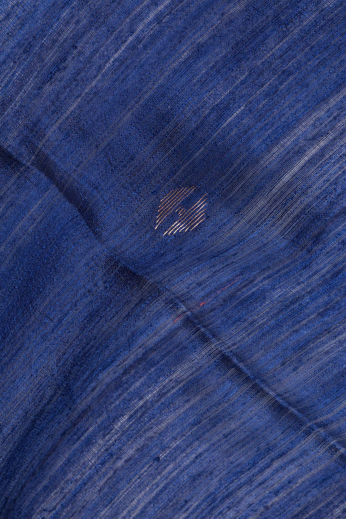 Close up of Pure Silk Navy Blue Dual Tone Jute Saree with Zari Butta on the body and Zari Border.  displaying folds