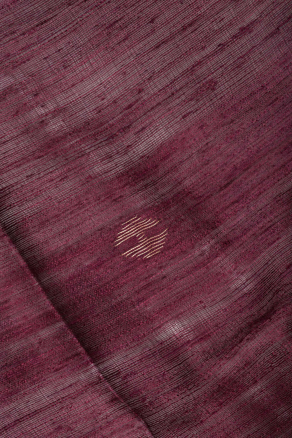 Close up of Pure Silk Brown Tussar Saree with Zari Butta on the body and Zari Border.  displaying folds