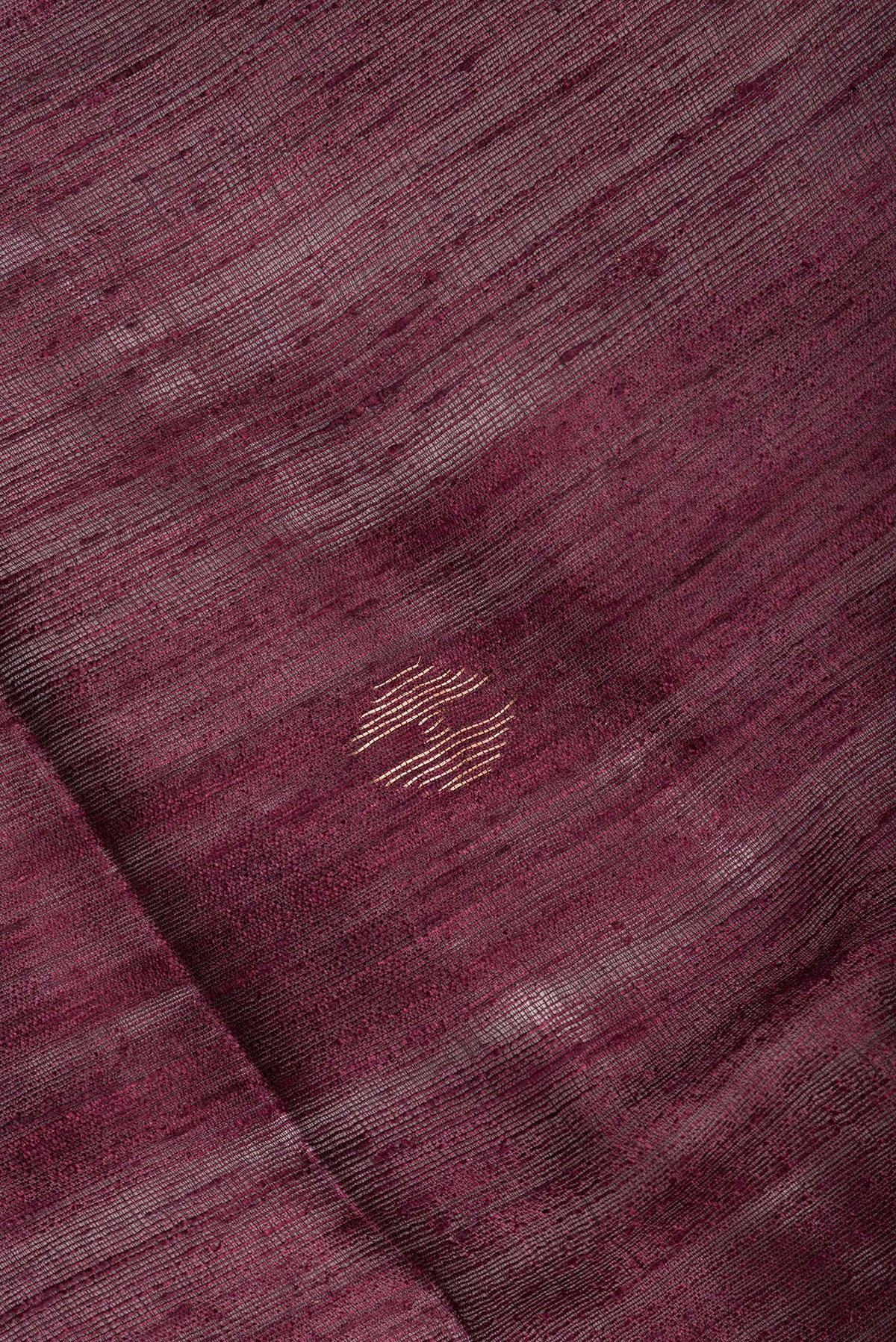 Close up of Pure Silk Brown Tussar Saree with Zari Butta on the body and Zari Border.  displaying folds