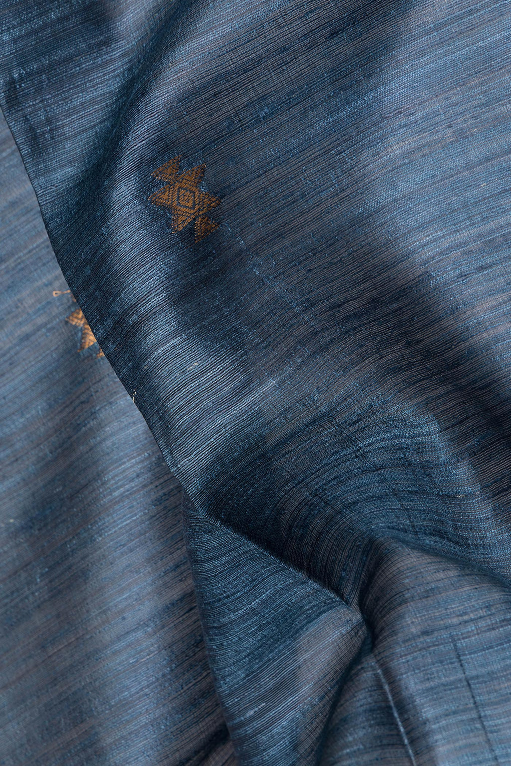 Close up of Grey Tussar Saree with Zari Butta on the body and Zari Border.  displaying folds