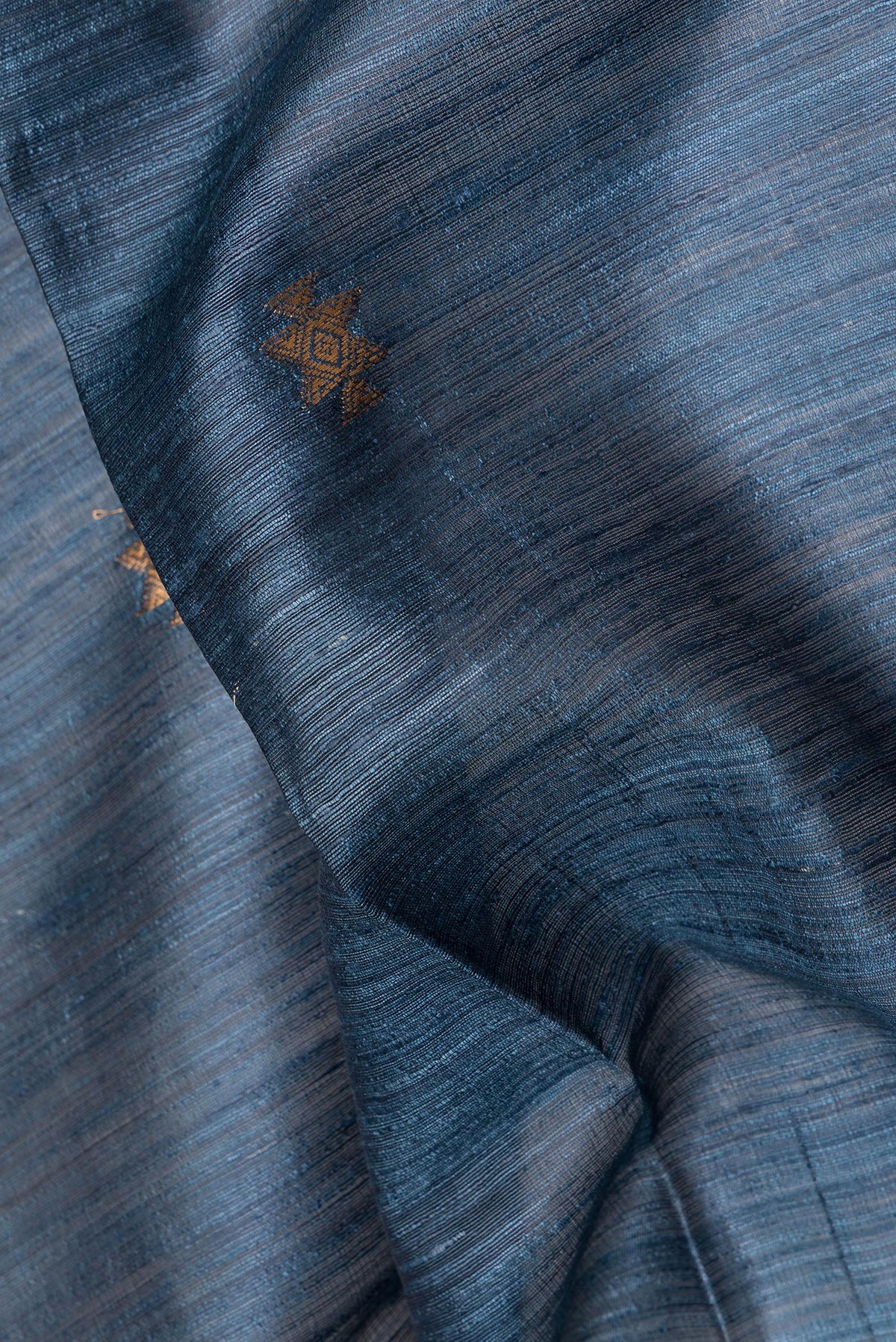 Close up of Grey Tussar Saree with Zari Butta on the body and Zari Border.  displaying folds