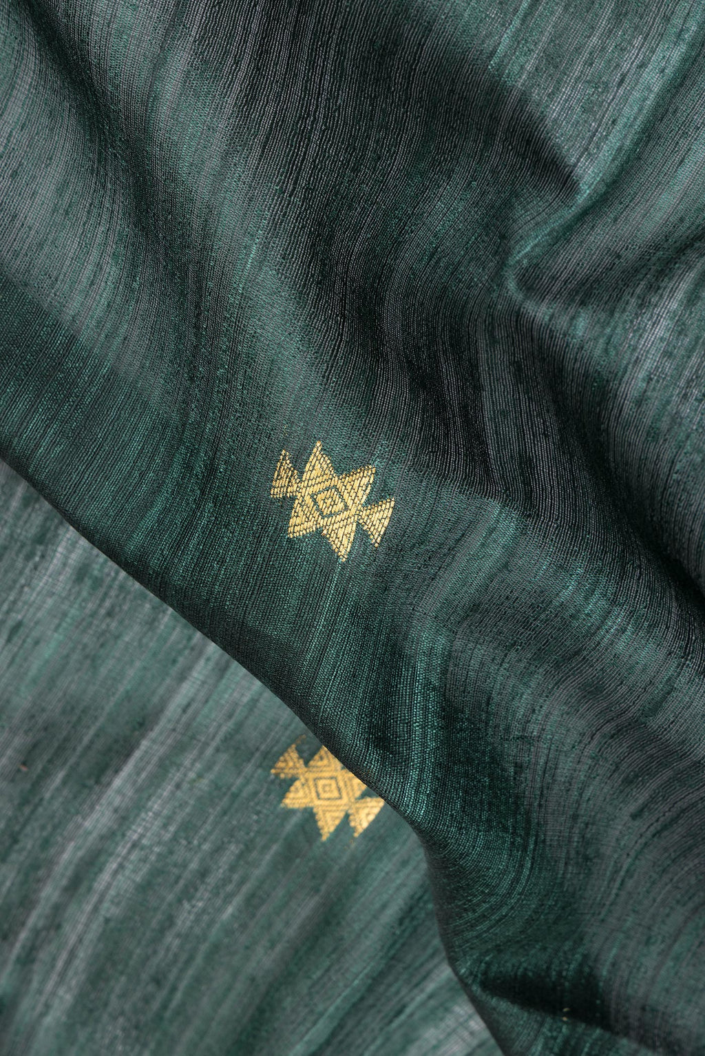 Close up of Pure Silk Green Dual Tone Jute Saree with Zari Butta on the body and Zari Border.  displaying folds