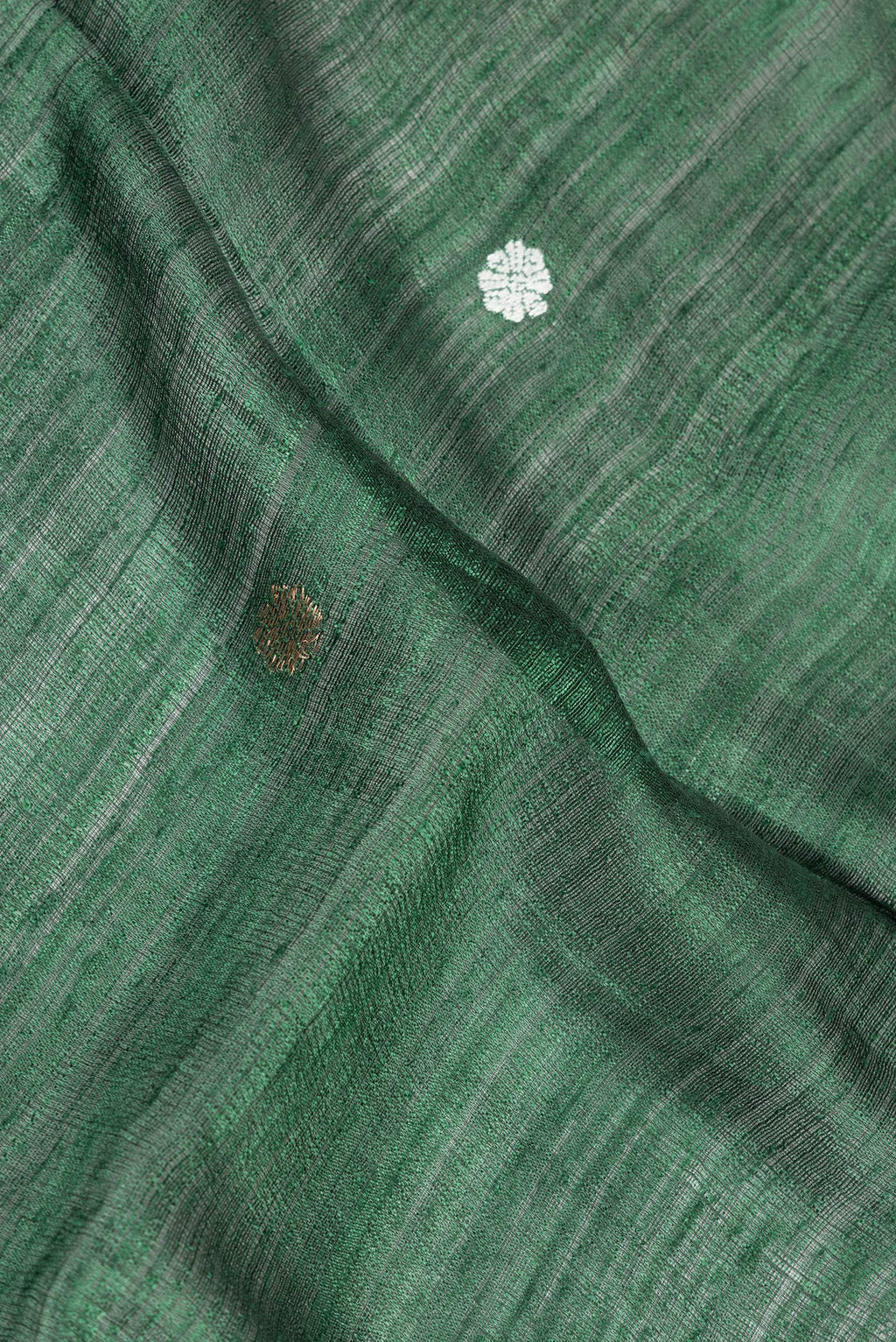 Close up of Green Tussar Saree with Zari Butta on the body and Fancy Border.  displaying folds