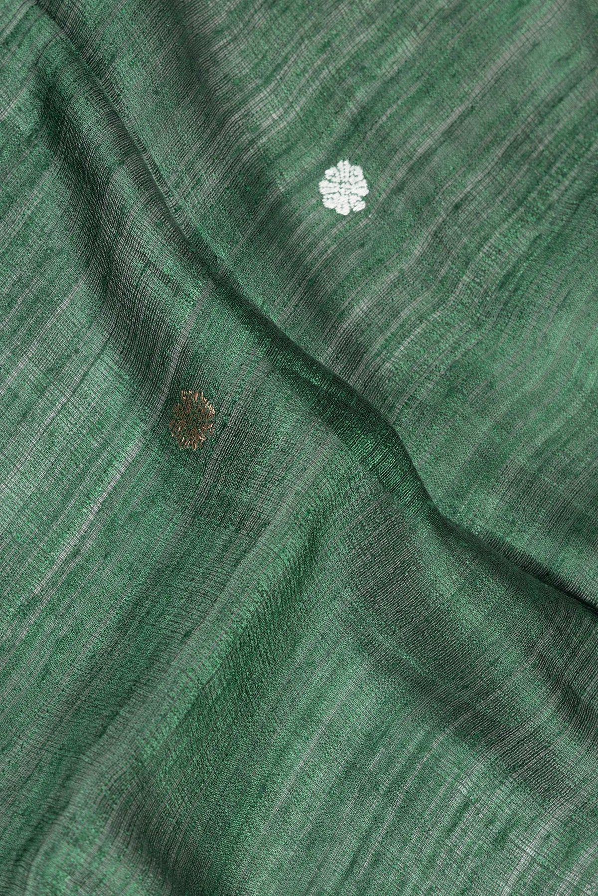 Close up of Green Tussar Saree with Zari Butta on the body and Fancy Border.  displaying folds