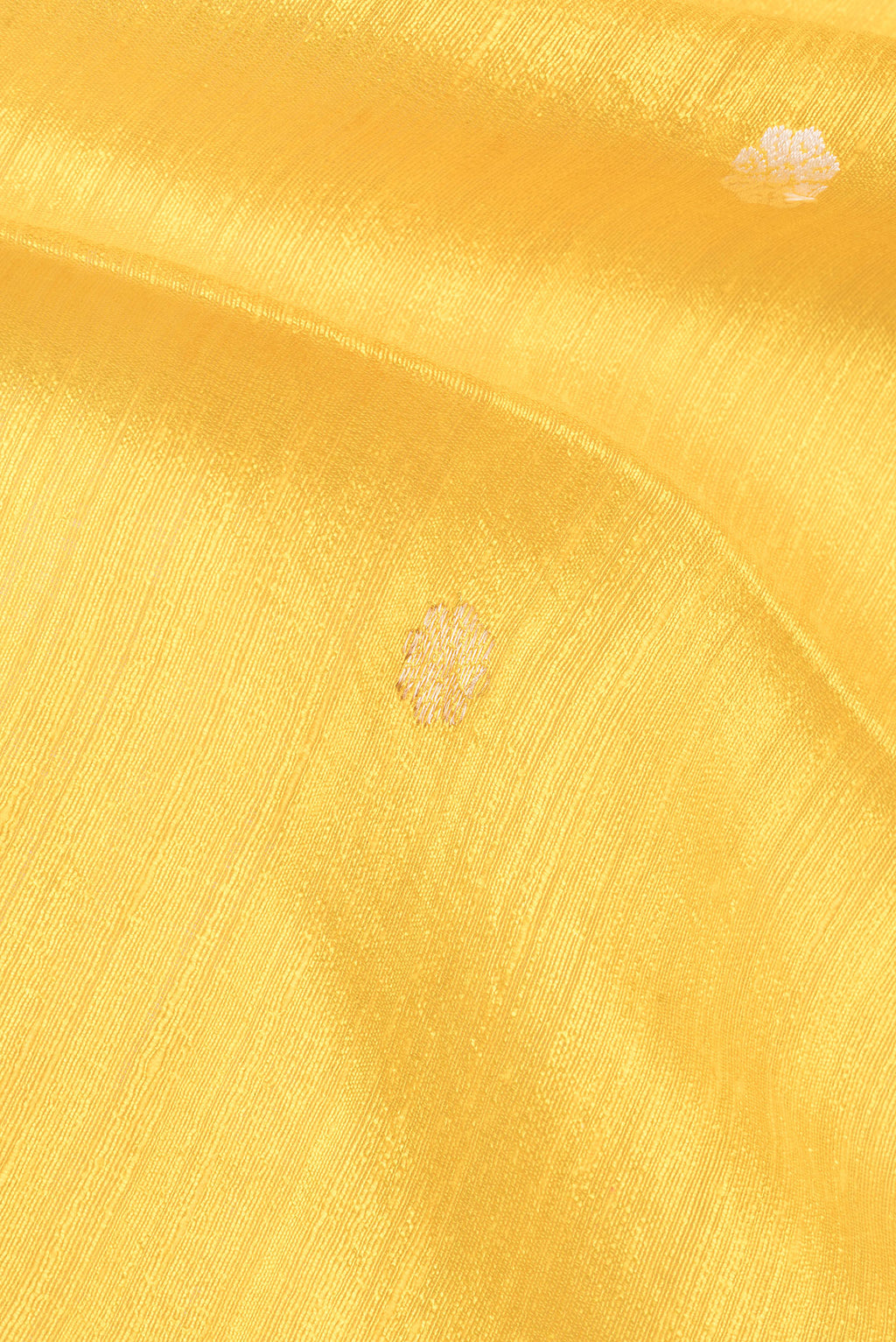 Close up of Pure Silk Lemon Yellow Tussar Saree with Zari Butta on the body and Fancy Border.  displaying folds