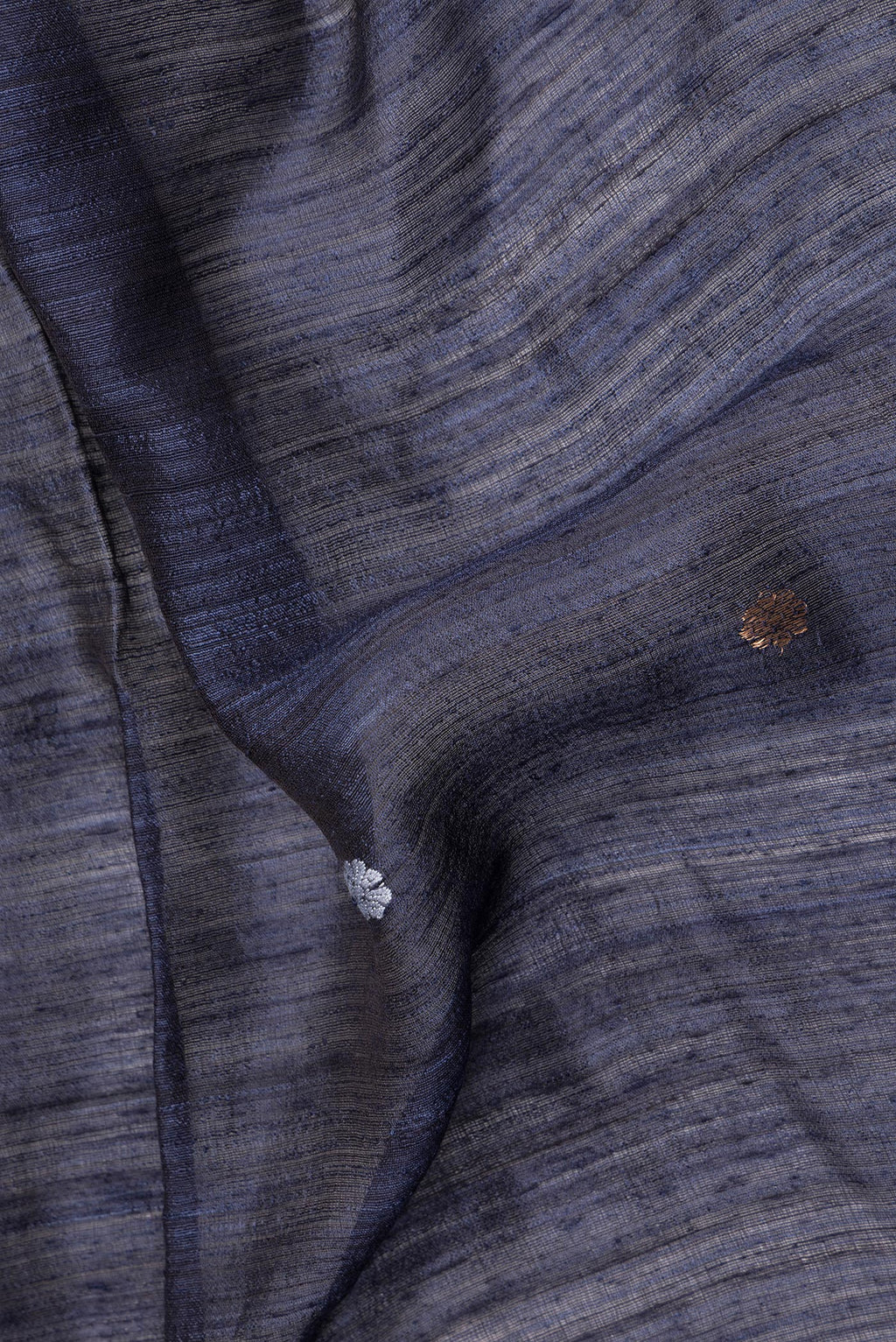 Close up of Navy Blue Tussar Saree with Zari Butta on the body and Fancy Border.  displaying folds