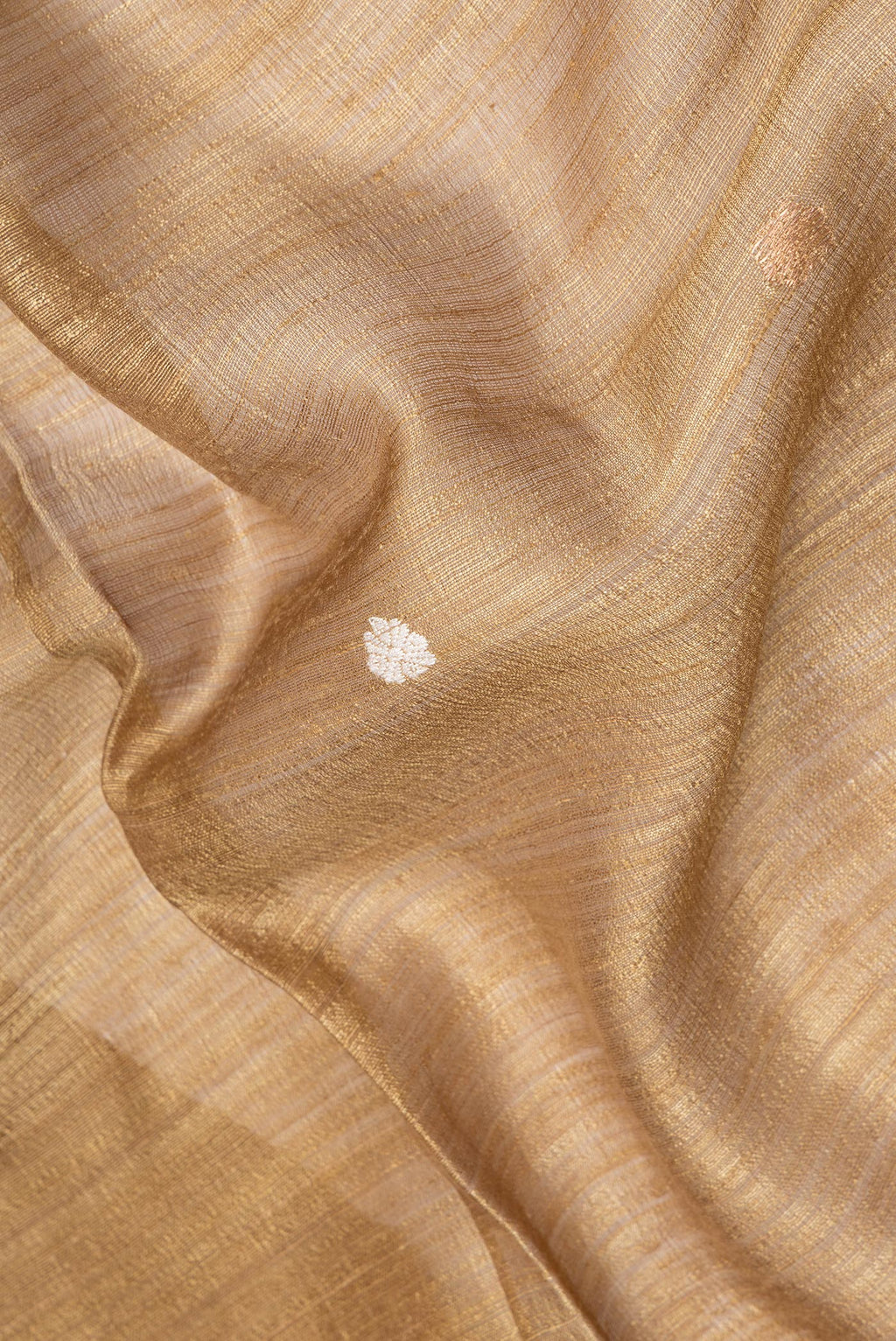 Close up of Pure Silk Gold Dual Tone Jute Saree with Zari Butta on the body and Fancy Border.  displaying folds