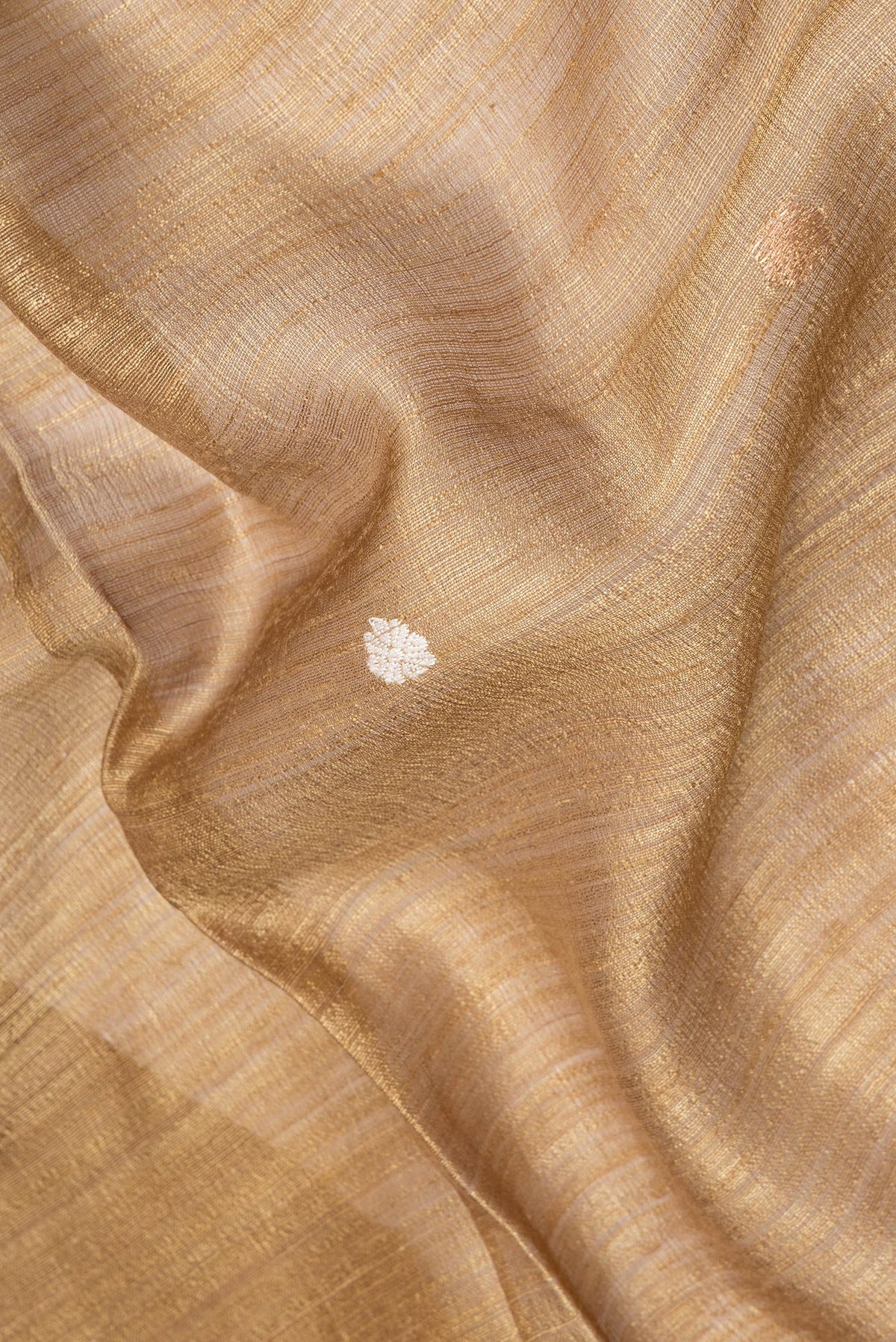 Close up of Pure Silk Gold Dual Tone Jute Saree with Zari Butta on the body and Fancy Border.  displaying folds