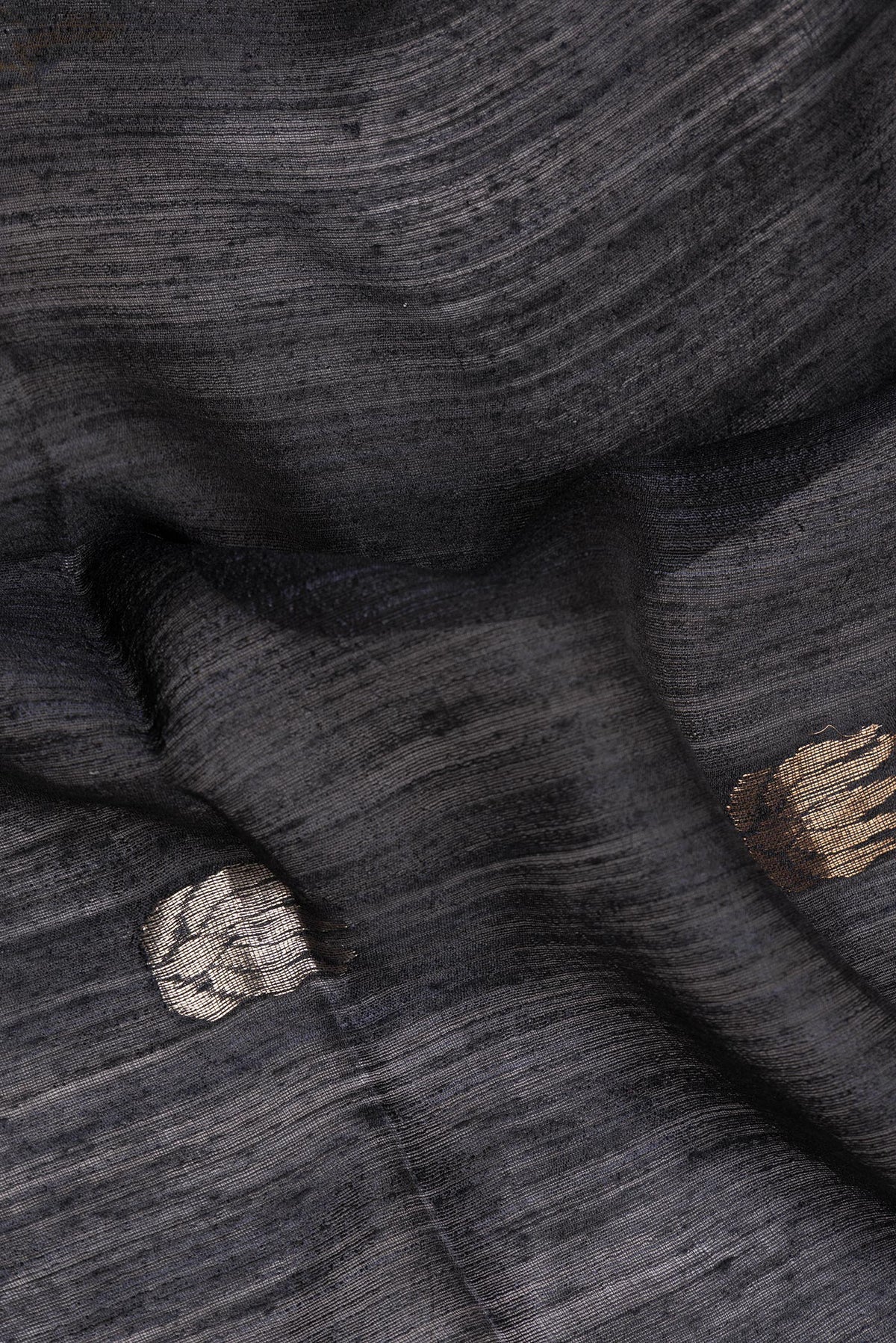 Close up of Black Tussar Saree with Zari Butta on the body and Zari Border.  displaying folds