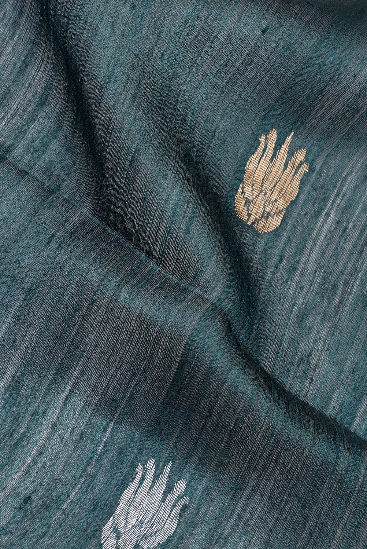 Close up of Pure Silk Bottle Green Tussar Saree with Zari Butta on the body and Zari Border.  displaying folds