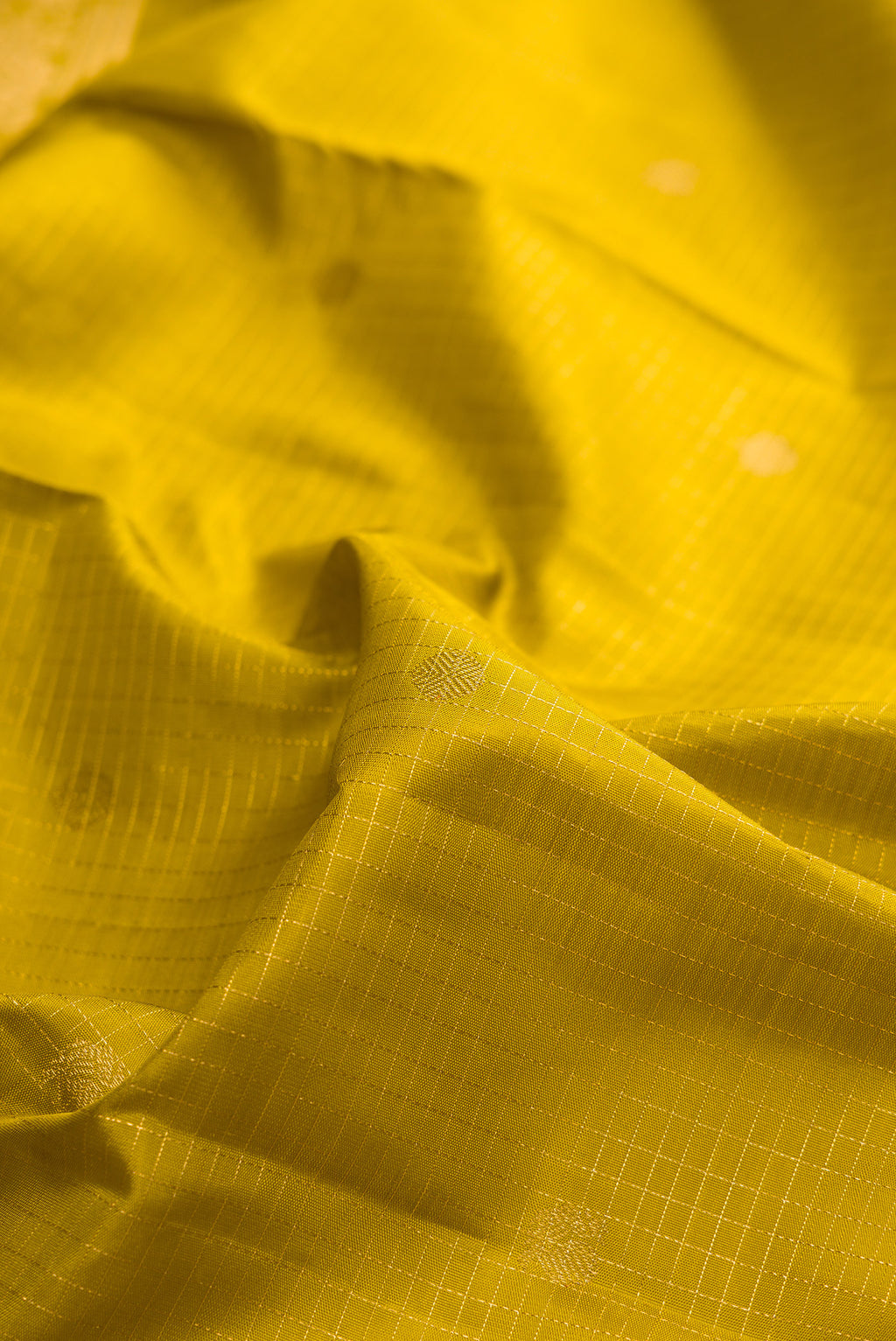 Close up of Pure Silk Mehandi Green Dual Tone Kanjivaram Saree with Checked design on the body and Zari Border.  displaying folds
