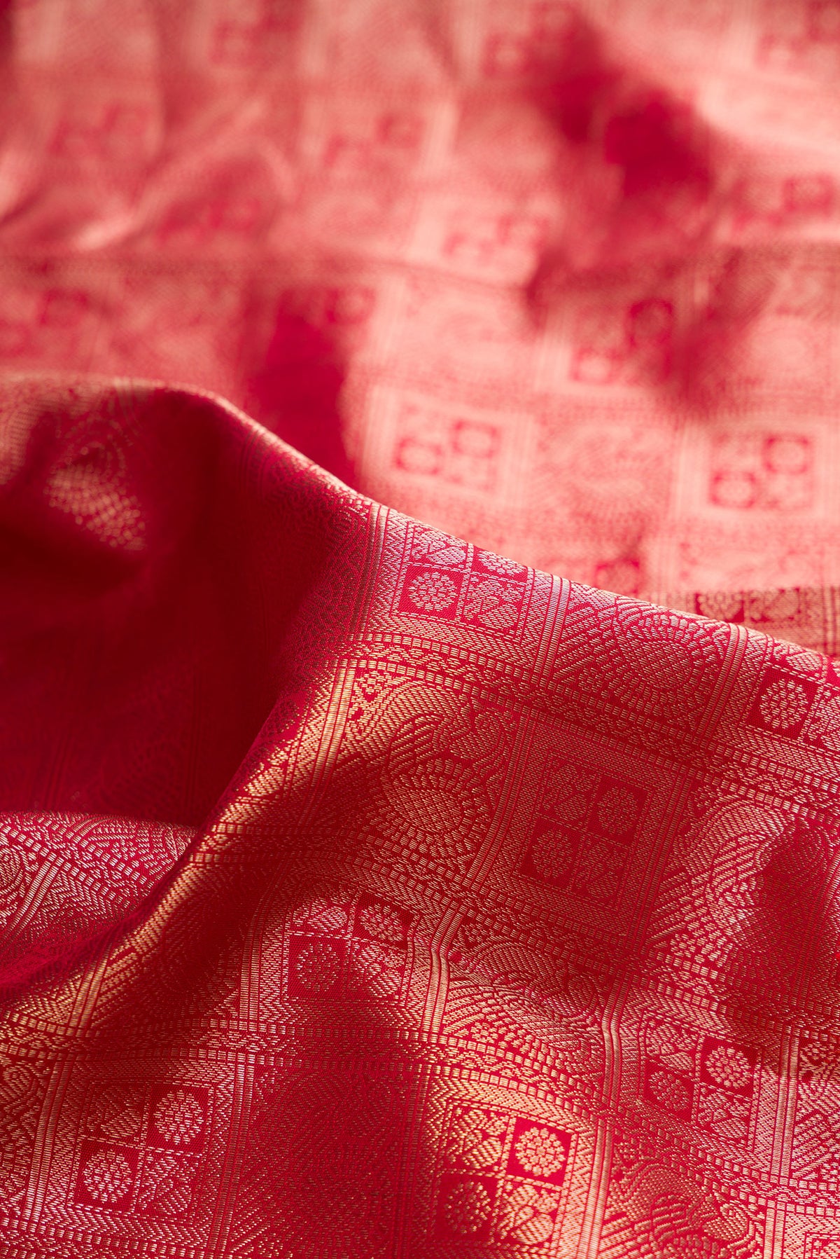 Close up of Pure Silk Red Kanchipuram Saree with Zari Brocade on the body and Zari Border.  displaying folds